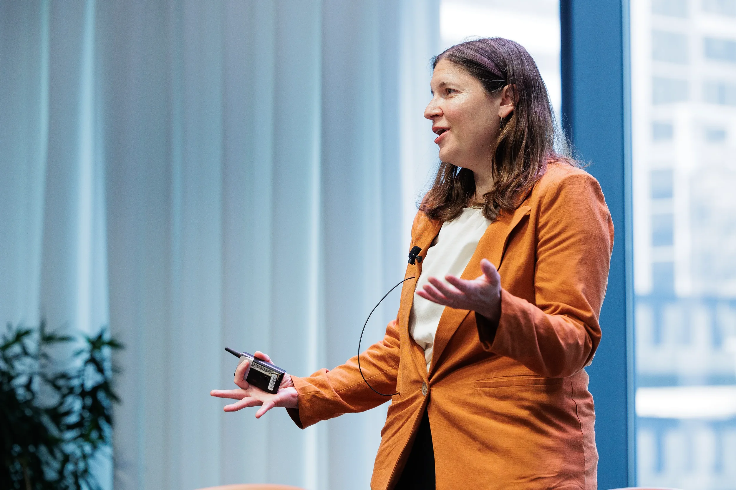 Speaker gestures while presenting with clicker in hand at Orlando industry conference