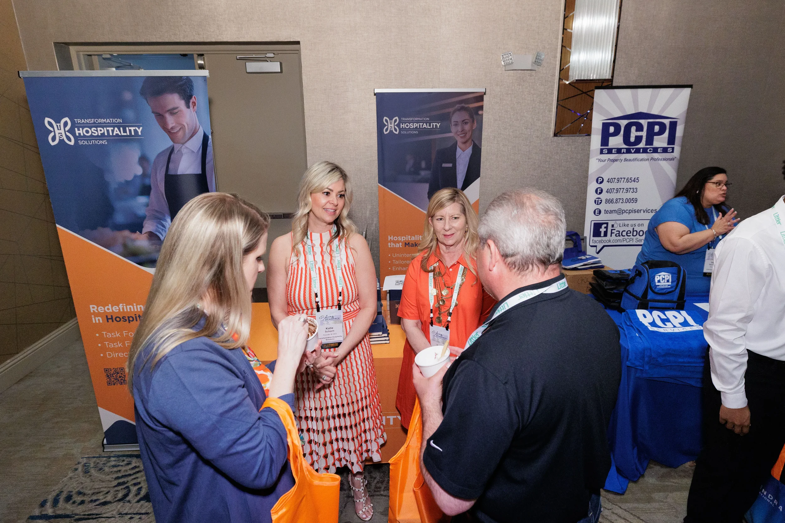 Booth staff and attendees converse in front of branded banners at Orlando industry conference trade show