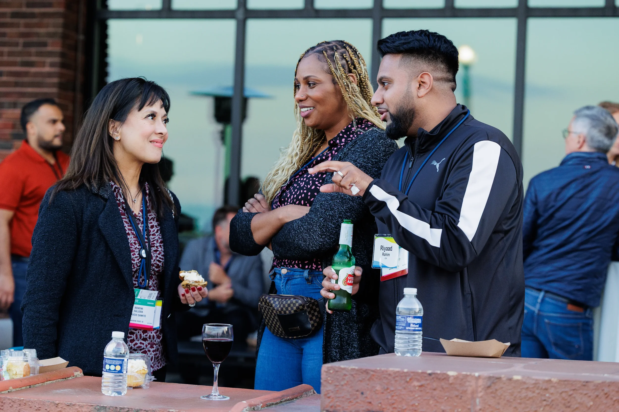 Three colleagues talk over drinks and appetizers at terrace networking reception at Orlando corporate event