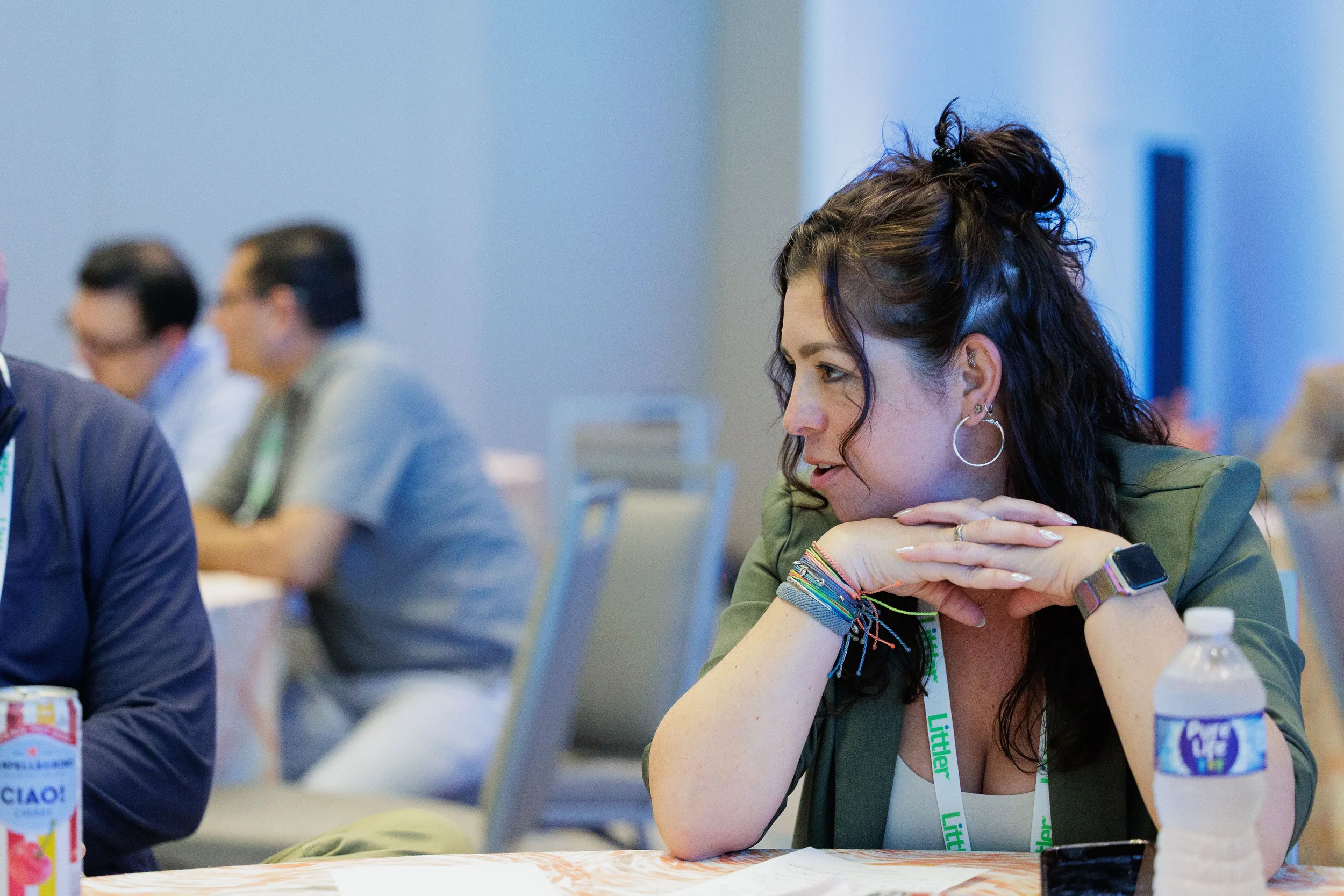 Attendee with lanyard leans forward listening intently at table during Chicago corporate event session