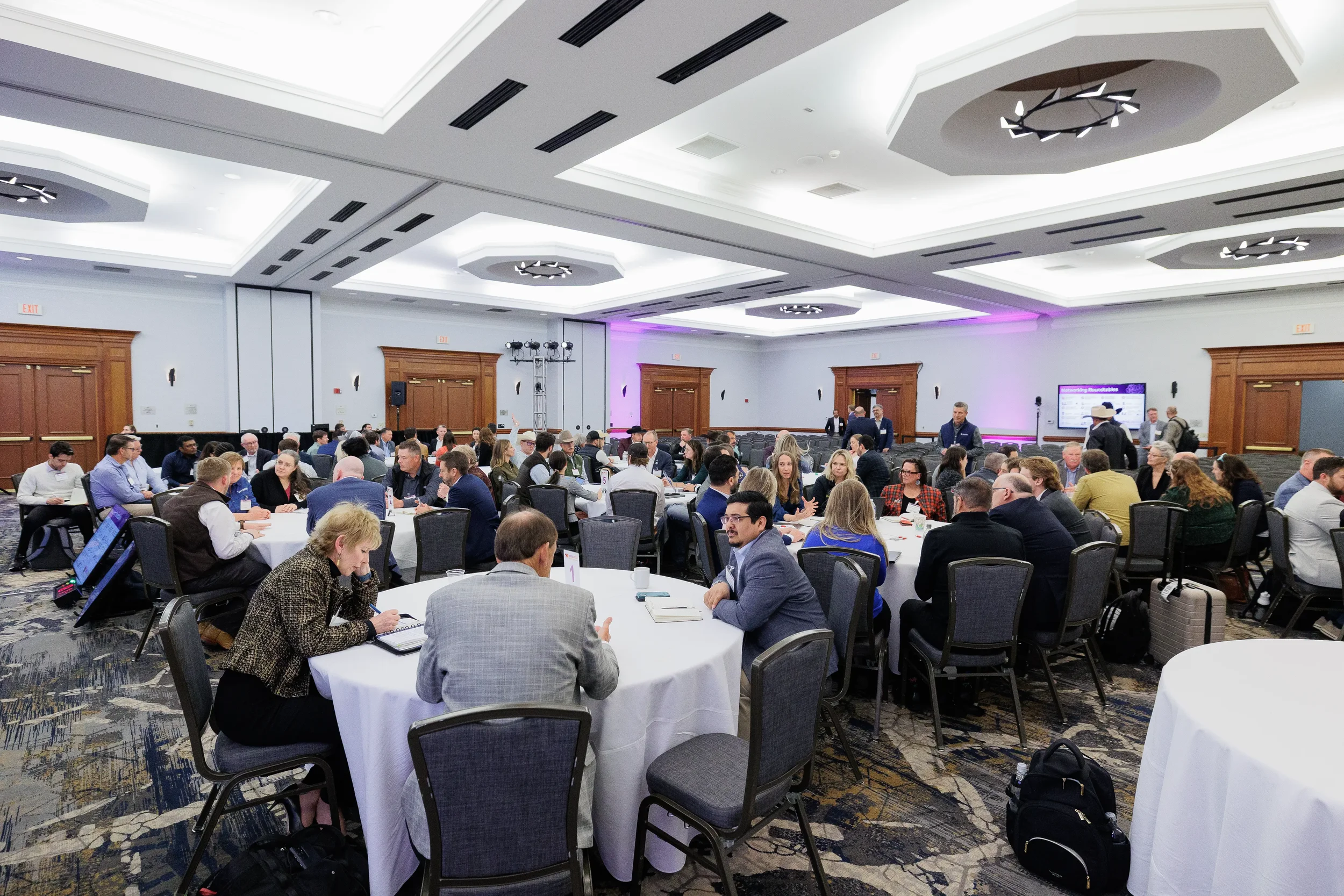 Wide view of attendees at networking roundtables during Chicago industry conference