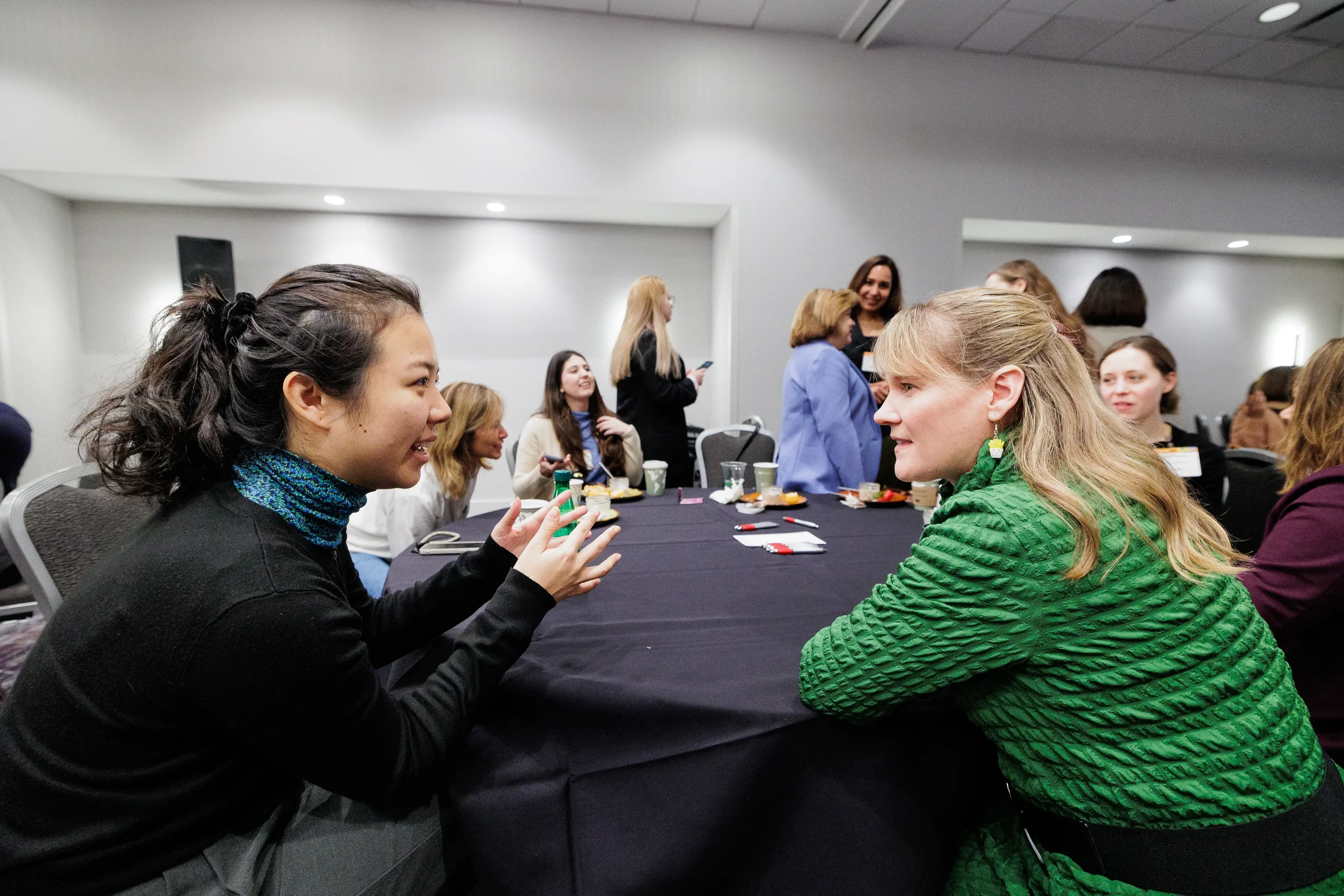 Two attendees converse closely at roundtable during Orlando networking reception