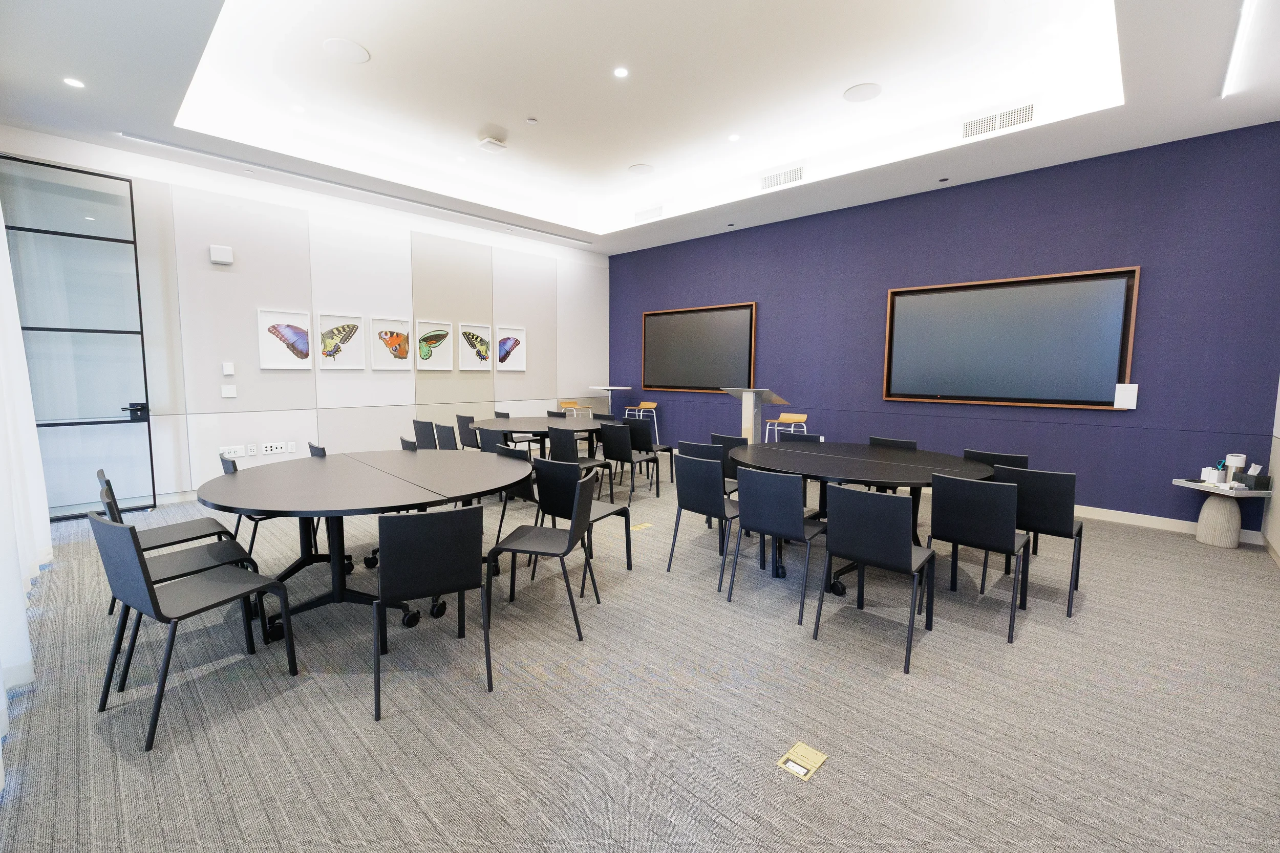 Empty meeting room with roundtable seating and screens set up for Orlando corporate conference
