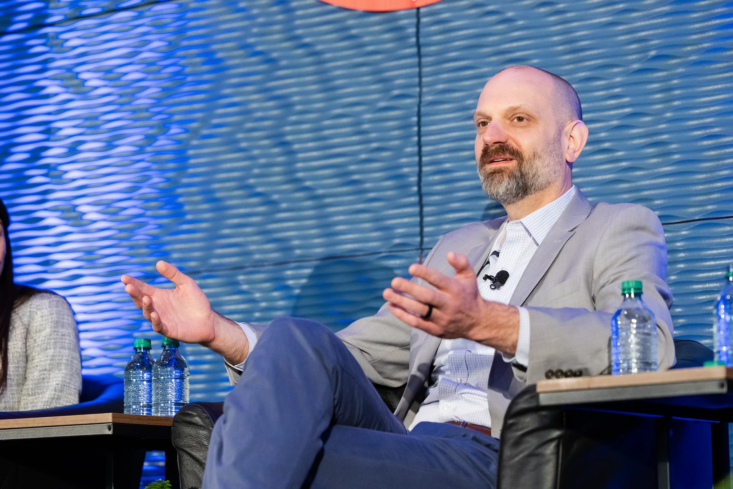 Panelist gestures with both hands while speaking on stage at Chicago corporate conference