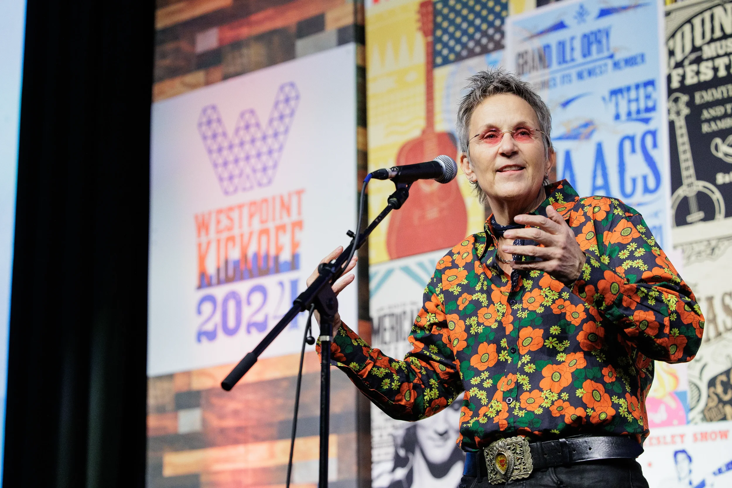 Speaker gestures while presenting at microphone on stage at Chicago corporate conference