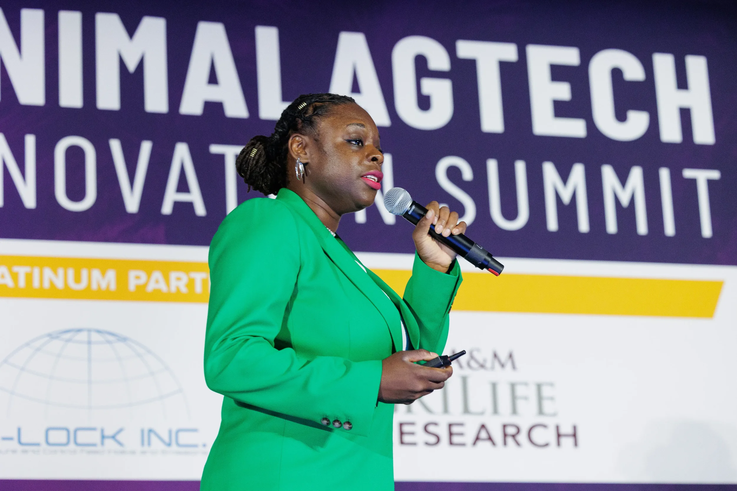 Speaker in green blazer presents on stage at Chicago industry conference
