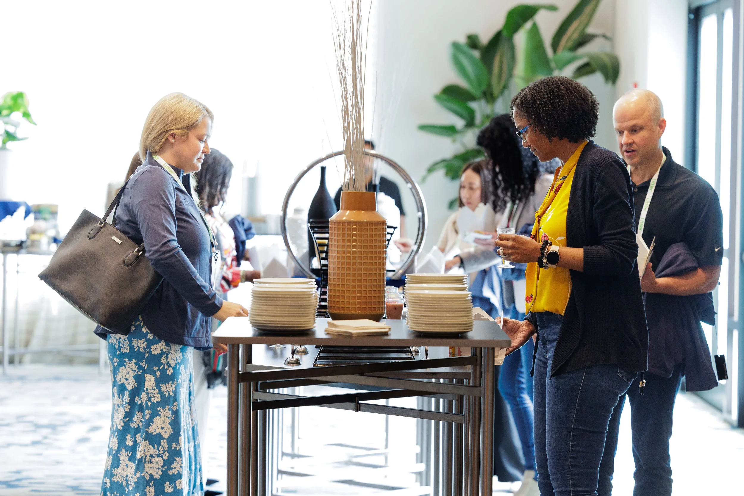 Attendees with lanyards gather at food station during Orlando corporate conference networking reception