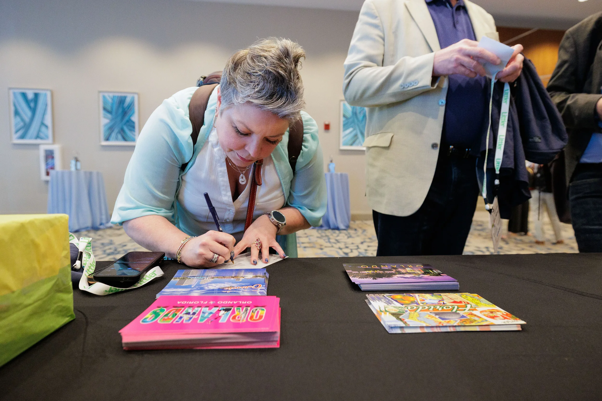 Attendee with lanyard signs materials at registration table during Chicago corporate conference
