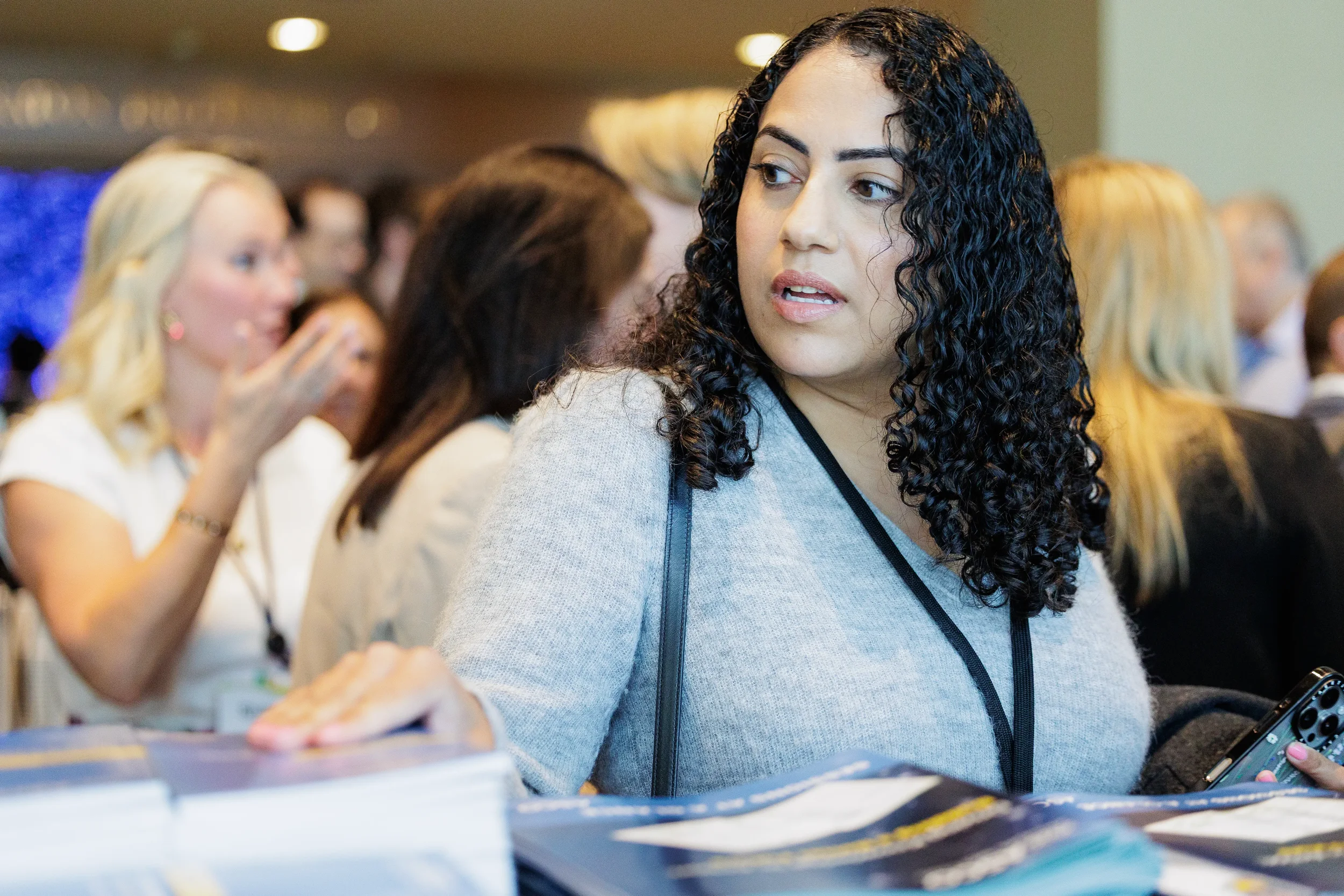 Attendee looks aside at table of brochures during registration at Orlando industry conference