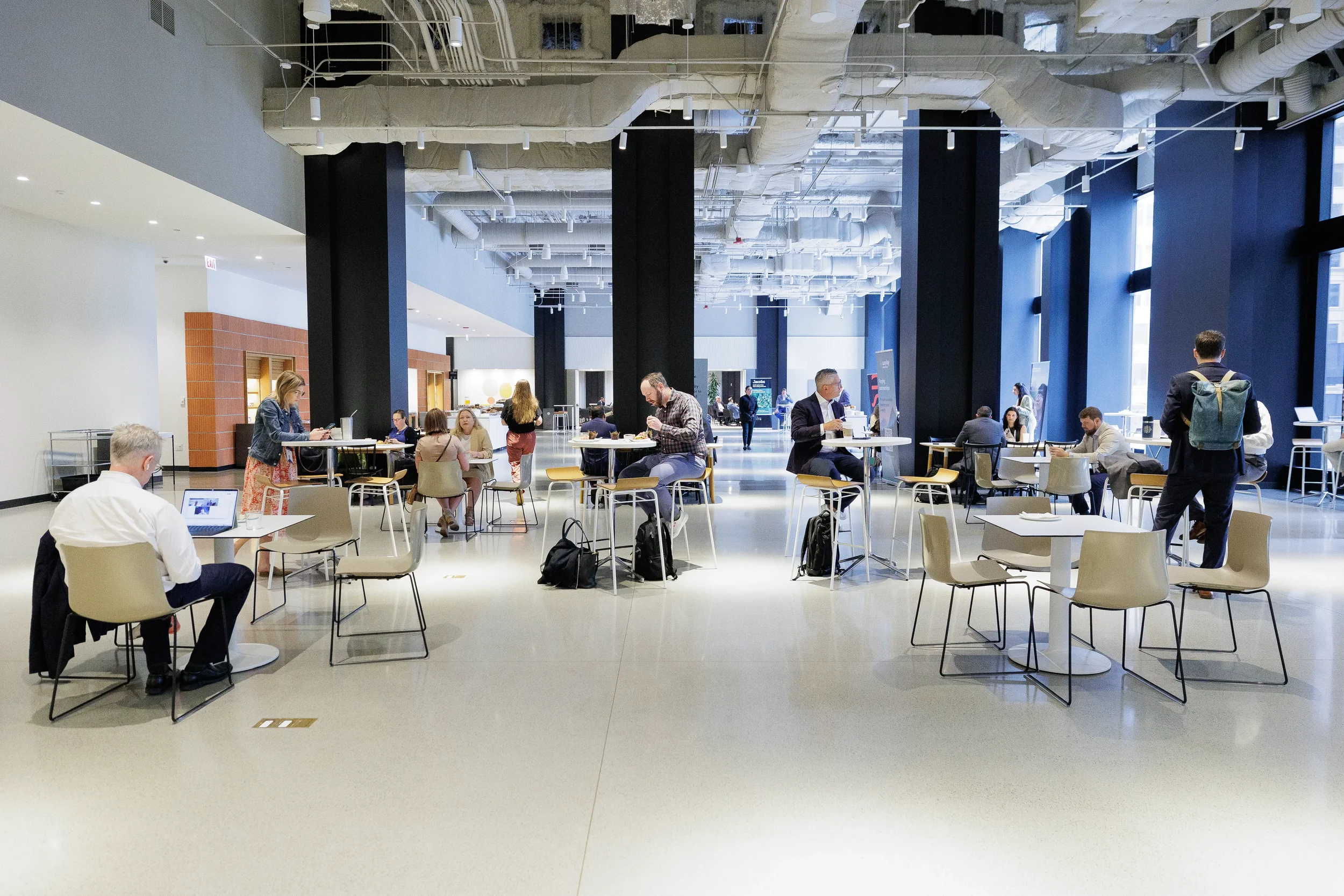 Attendees sit at lounge tables eating and conversing during Chicago corporate conference break