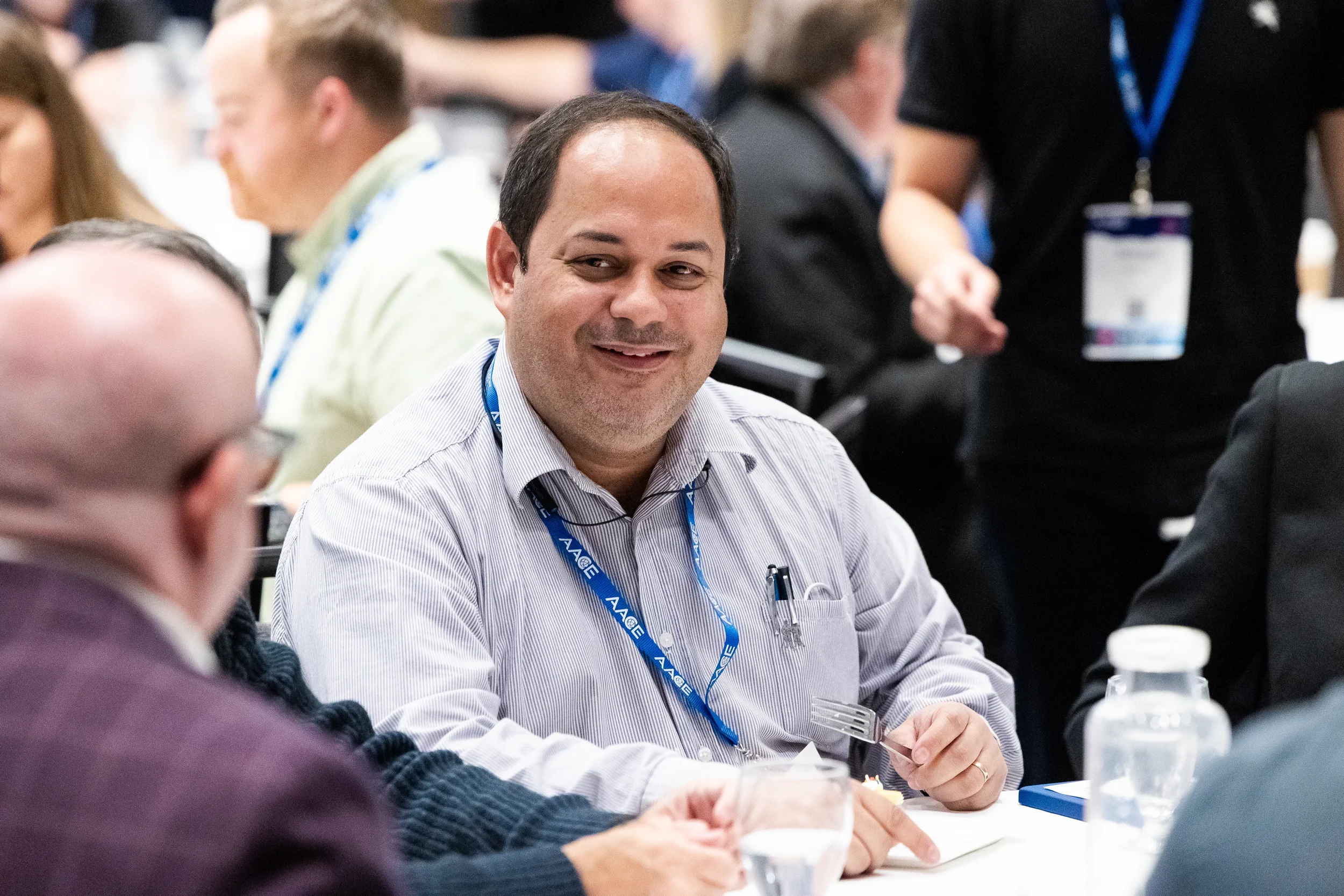 Conference attendee smiles during networking lunch at AACE International 2024 in Orlando