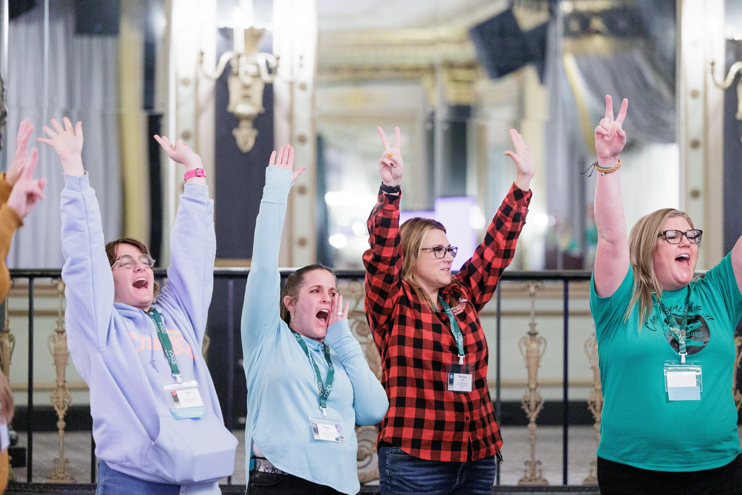 Attendees cheer with hands raised in ornate ballroom at Chicago nonprofit conference event