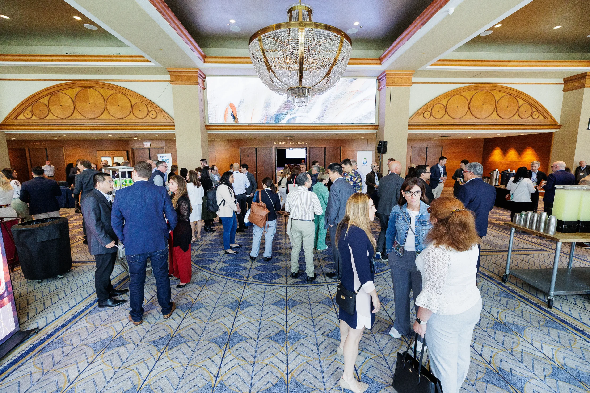 Attendees mingle in lobby during networking break at Orlando corporate conference