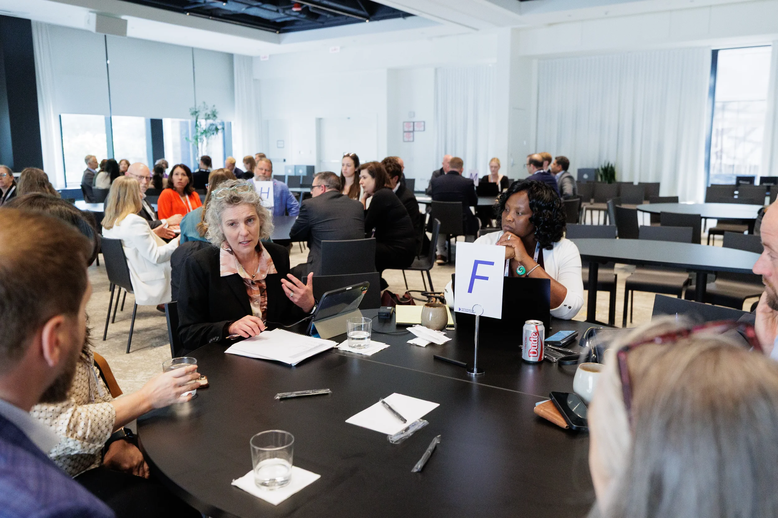 Attendees engage in roundtable discussion while seated at Orlando industry conference session