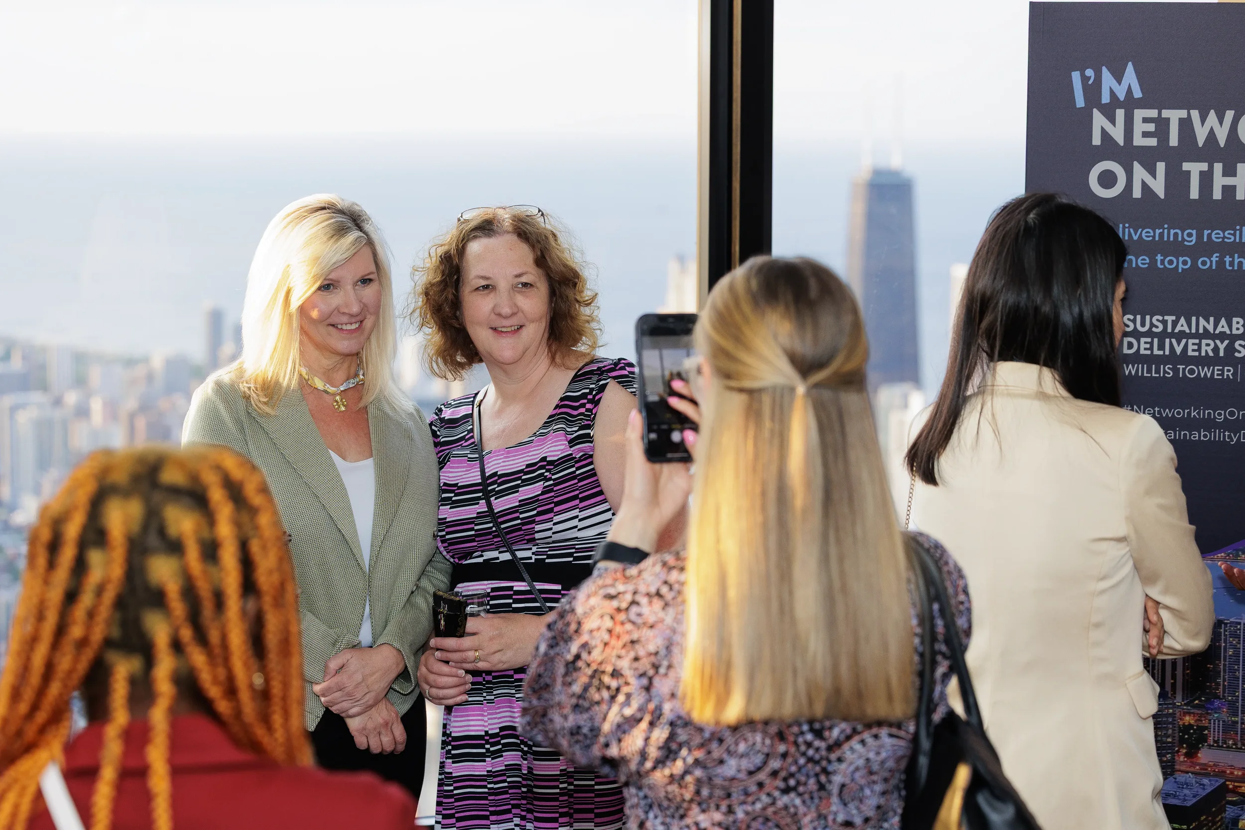 Attendees pose together for photo with skyline view during Orlando corporate event reception