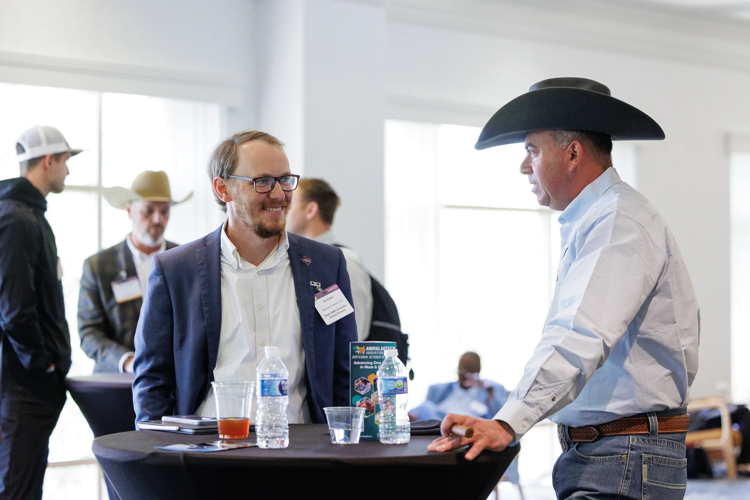 Two attendees converse at cocktail table during networking break at Chicago corporate conference
