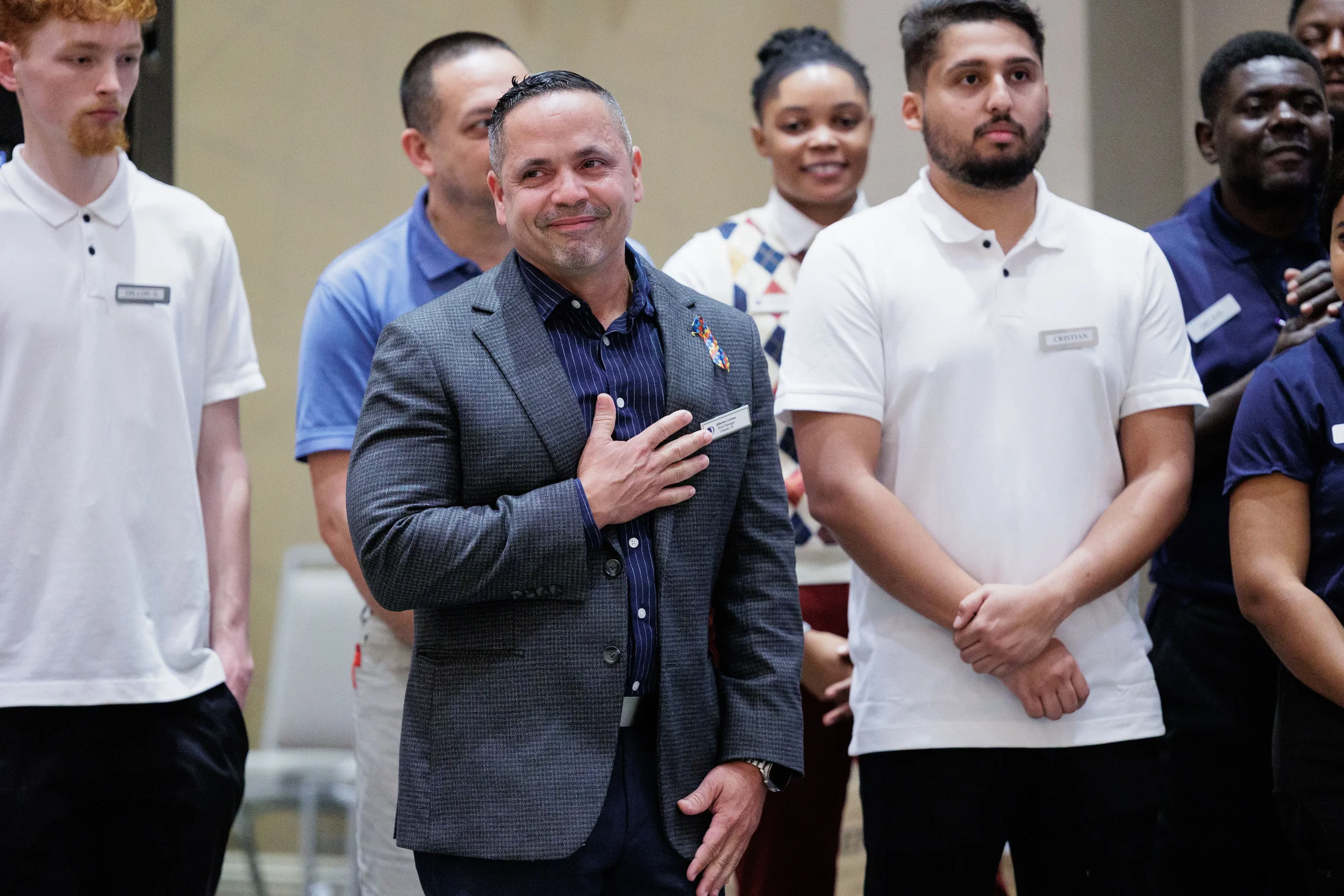 Attendee places hand over heart during emotional moment surrounded by group at Orlando conference