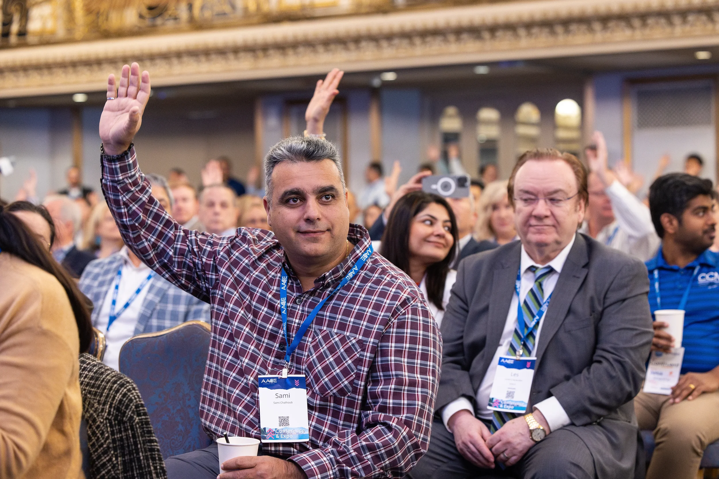 Conference attendee raises hand during general session at Orlando corporate event
