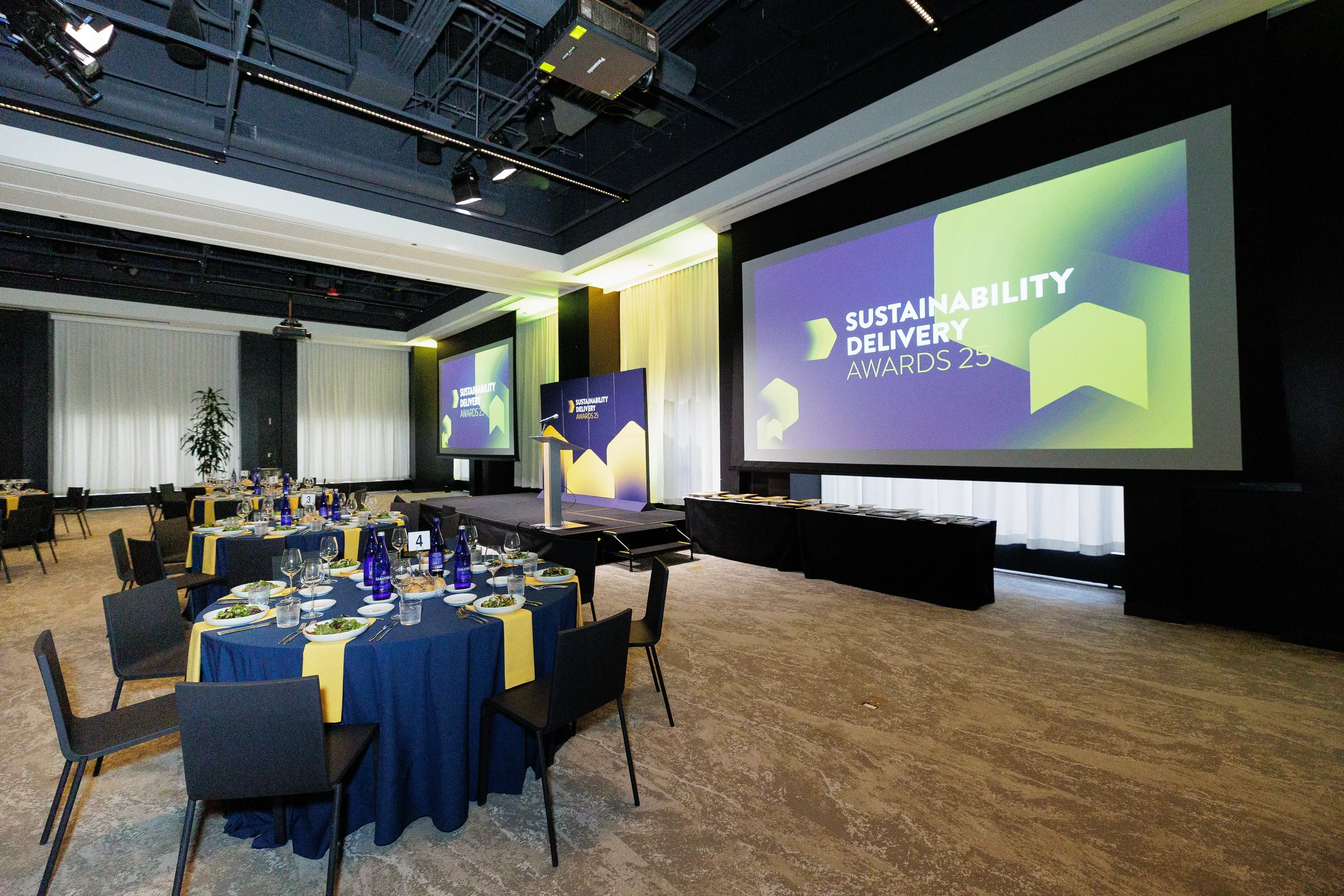 Ballroom set with round tables and dual screens ahead of Orlando corporate awards ceremony