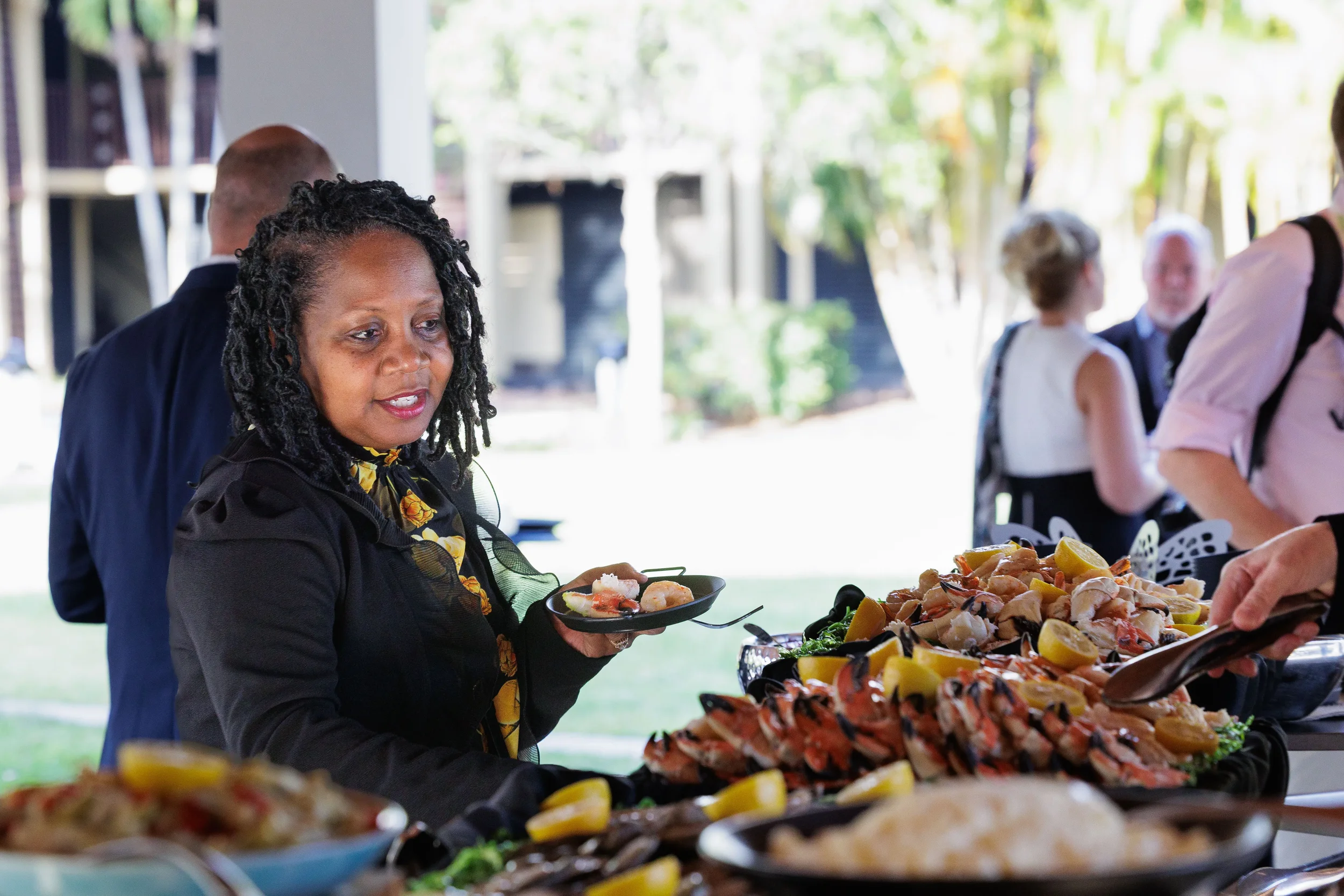 Attendee selects food from outdoor seafood buffet station during Chicago corporate event reception