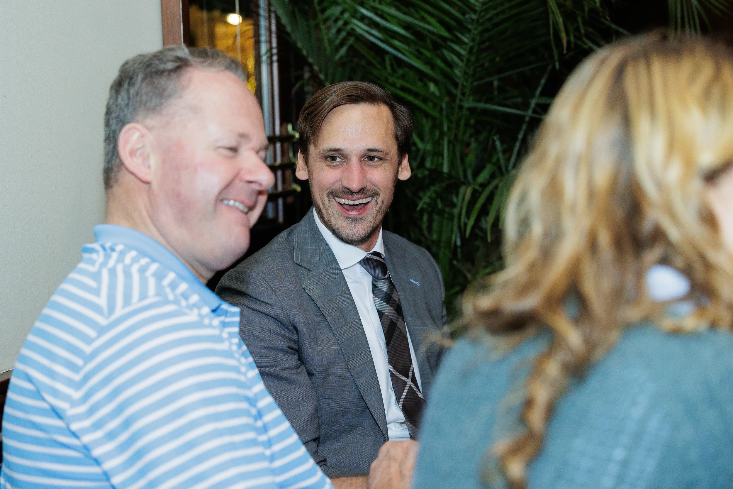 Two men at a Chicago conference smiling. A third person is in the foreground showing the back of their head.