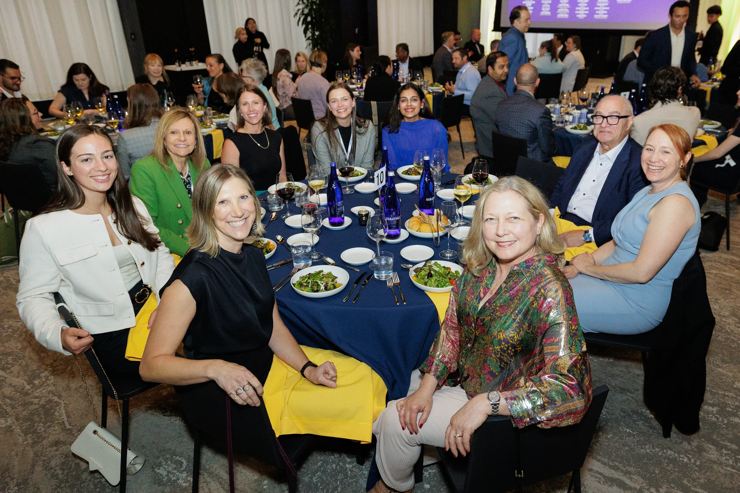 Group of attendees smile together at dinner table during Orlando corporate awards event
