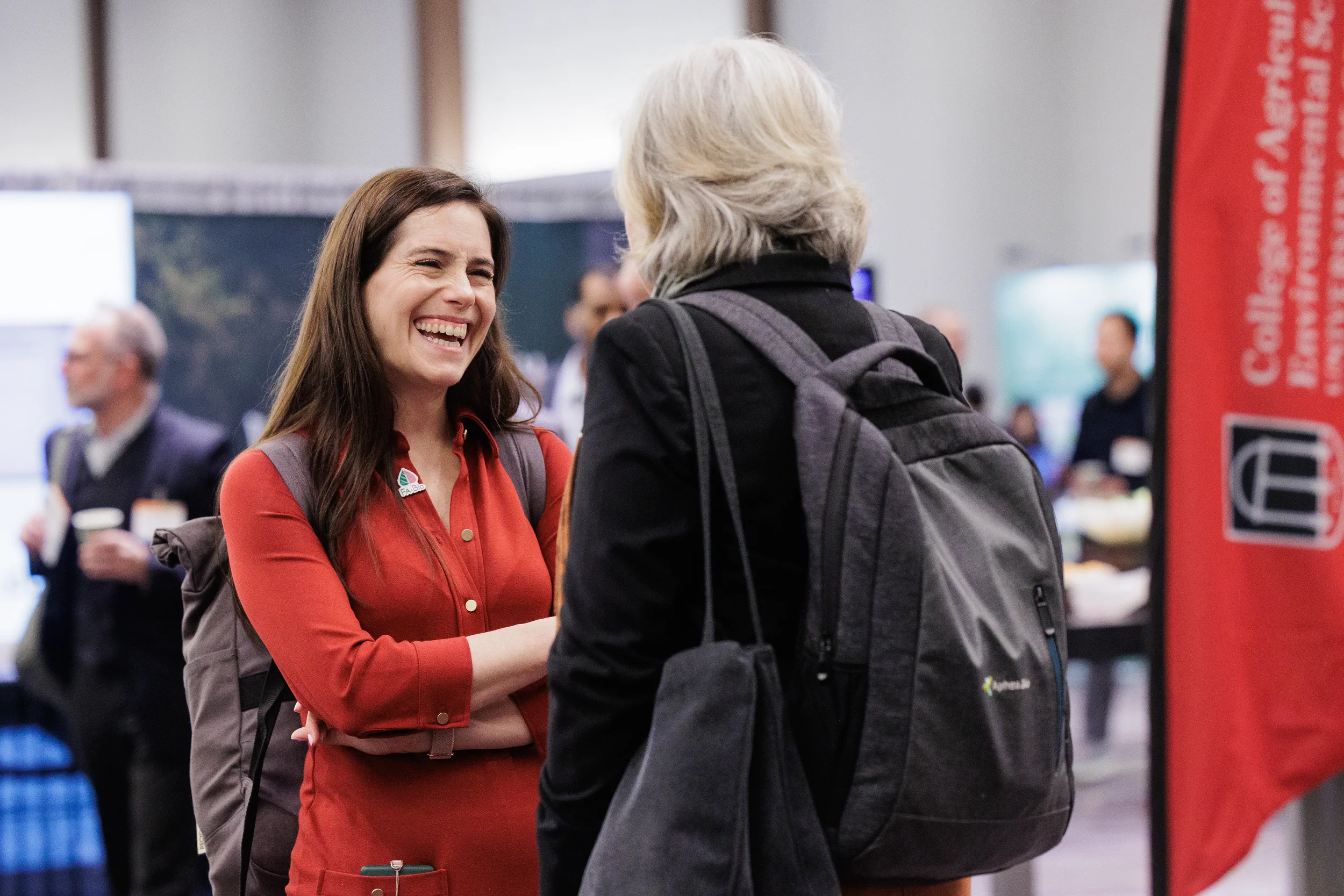 Two smiling badged attendees share a laugh while networking on Chicago corporate conference expo floor