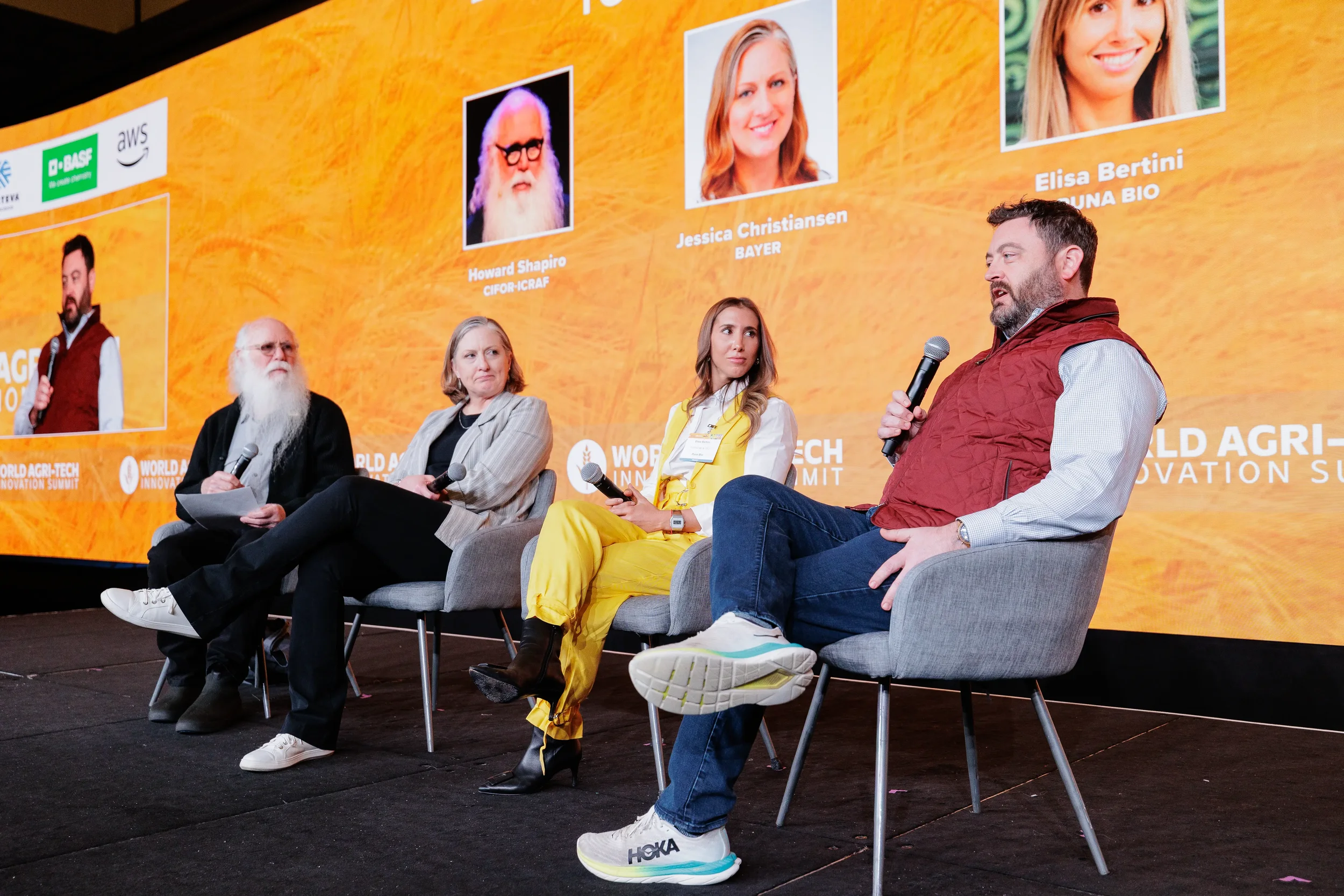 Four panelists discuss topics on stage during Orlando industry conference panel