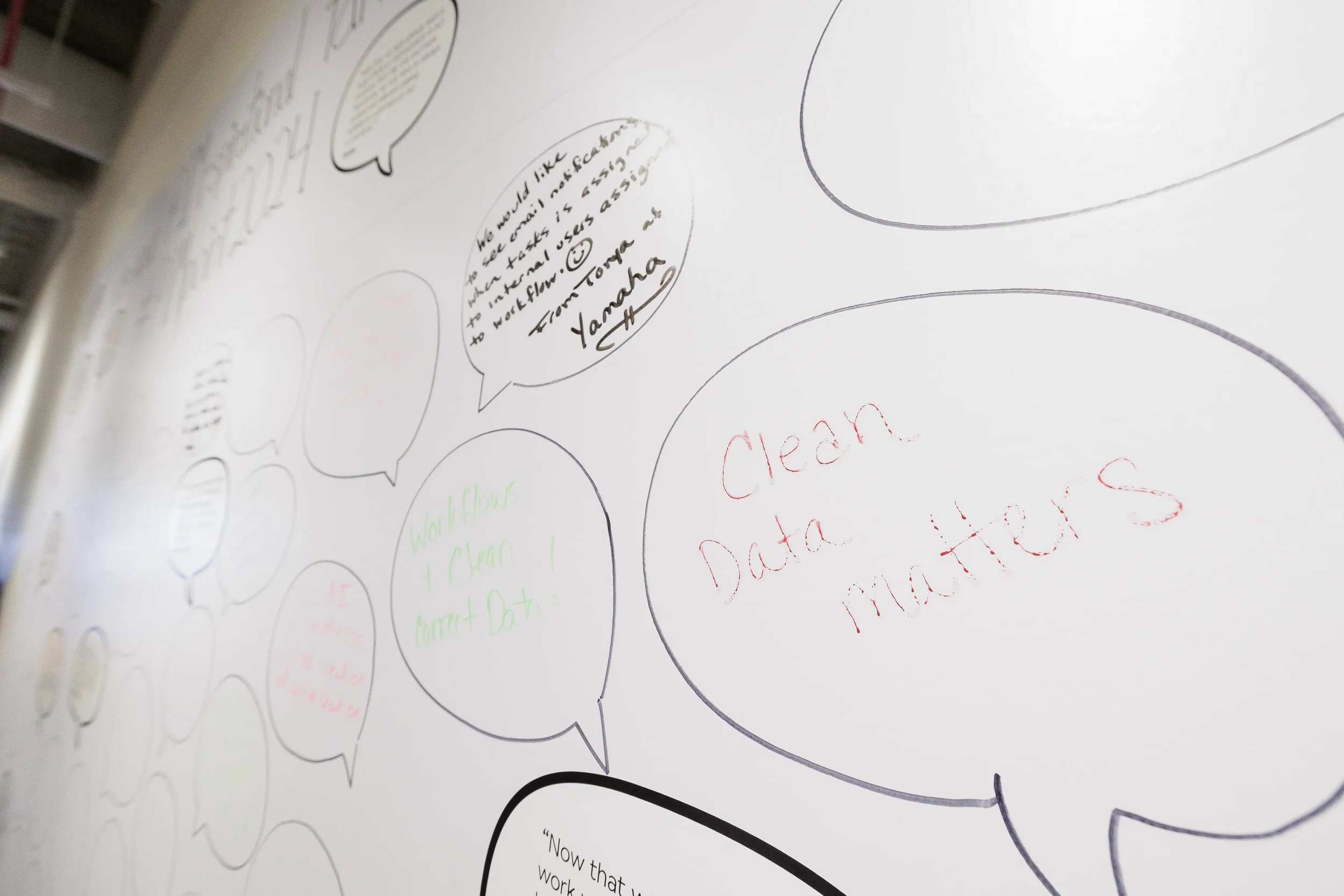 Handwritten attendee comments in speech bubbles on interactive feedback wall at Chicago industry conference