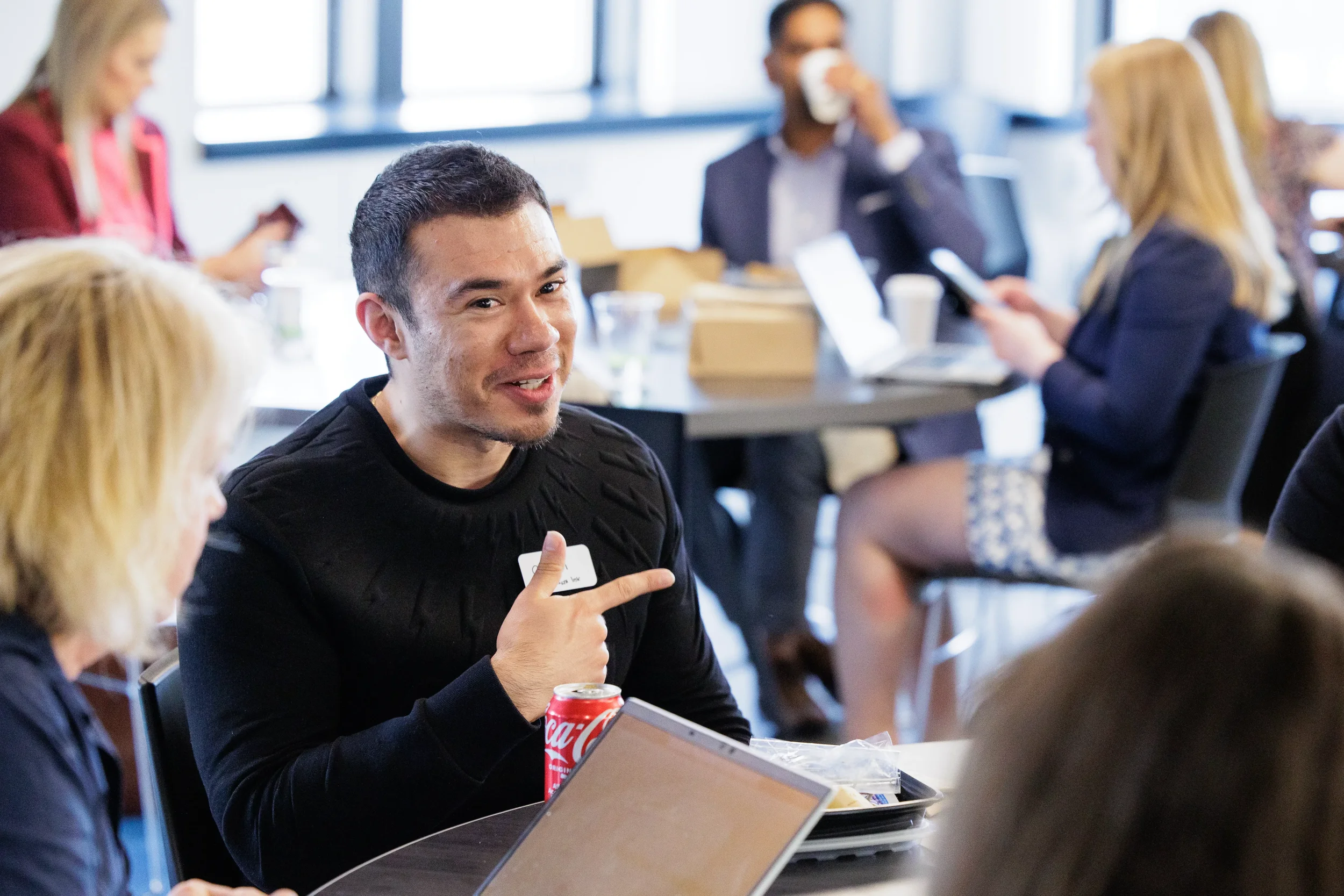Male attendee gestures animatedly while conversing at a lunch table during Orlando industry conference
