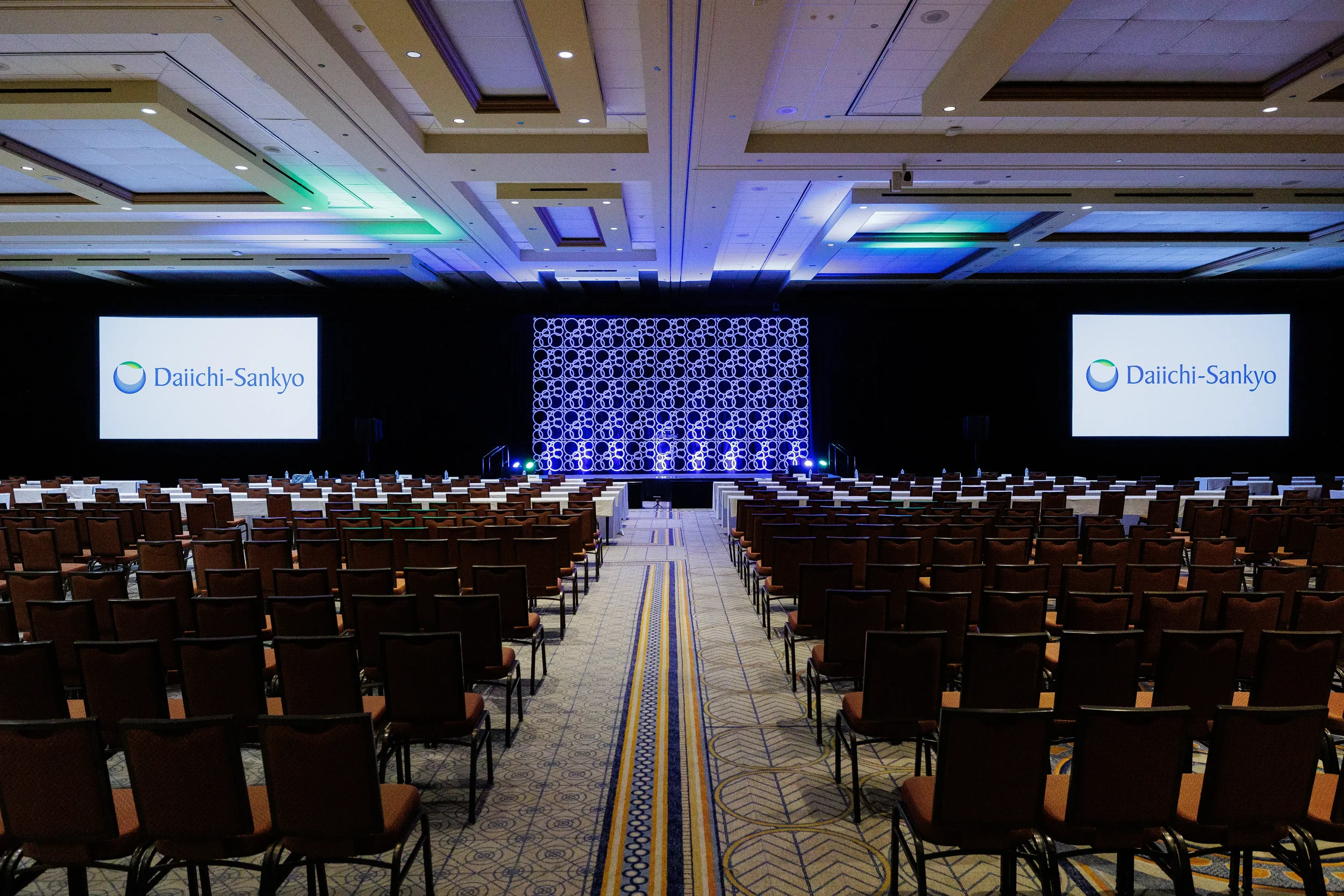 Empty ballroom set up with branded stage backdrop before Orlando corporate conference