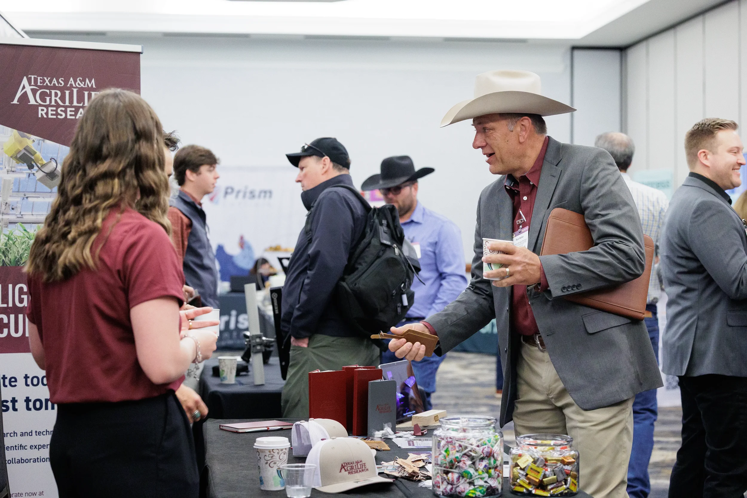 Attendee exchanges business card with exhibitor at expo booth during Chicago trade show