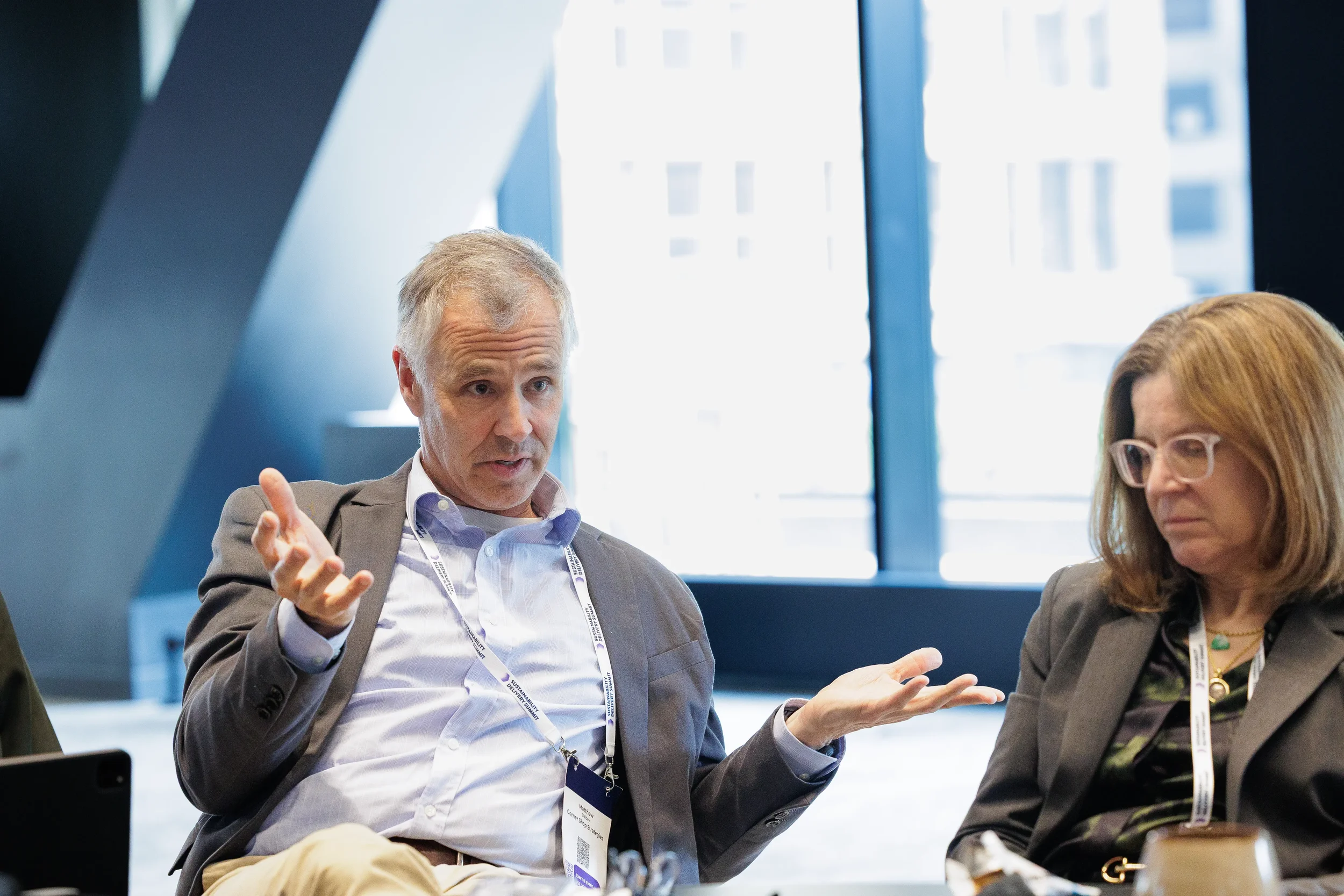 Panelists engage in seated discussion with animated gestures at Orlando corporate conference