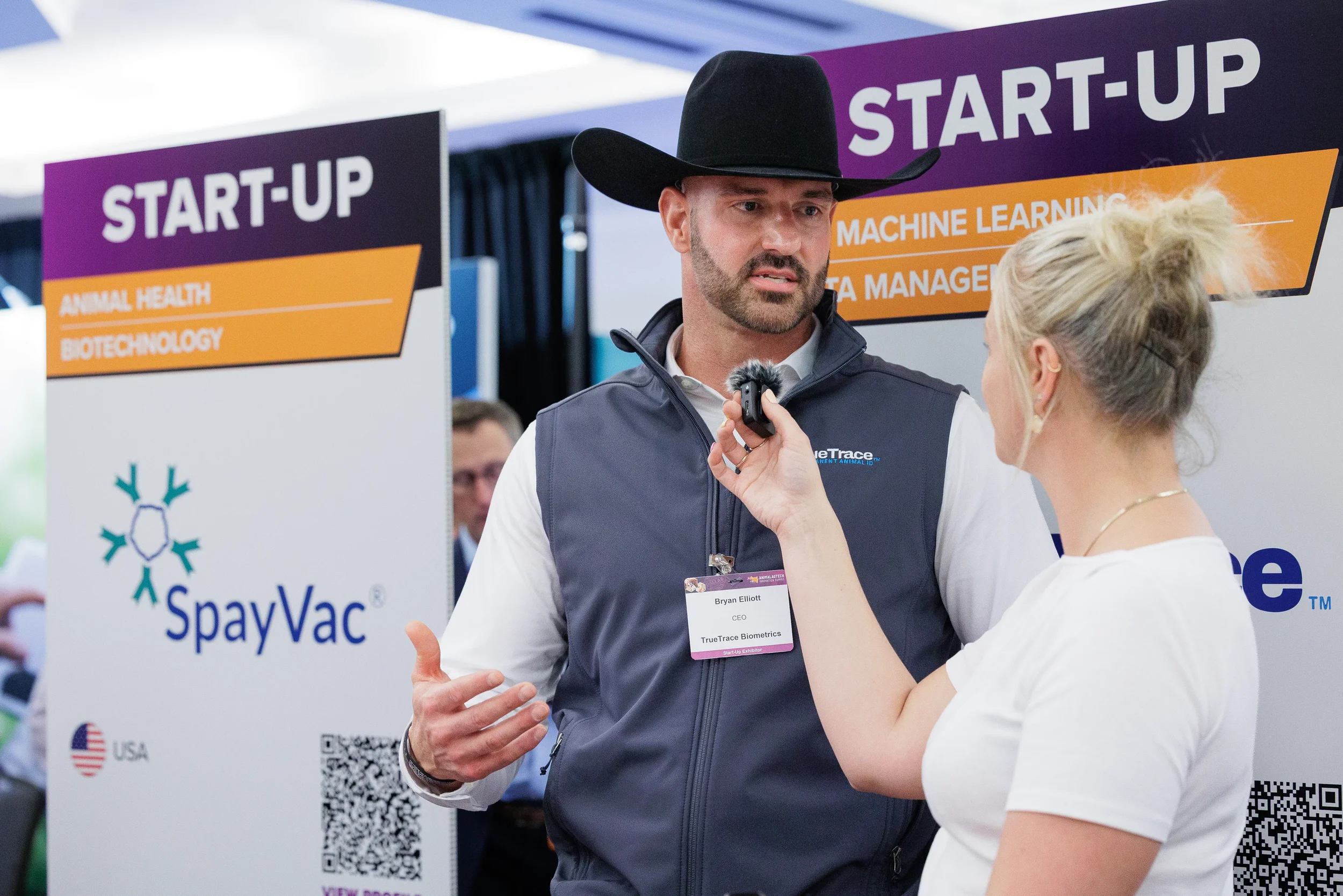 Exhibitor is interviewed at startup booth during Orlando industry conference expo