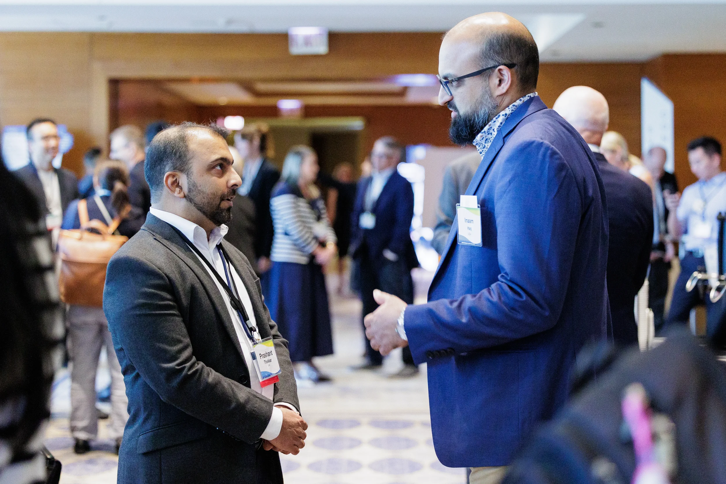 Two attendees in conversation with name badges during networking reception at Chicago corporate event