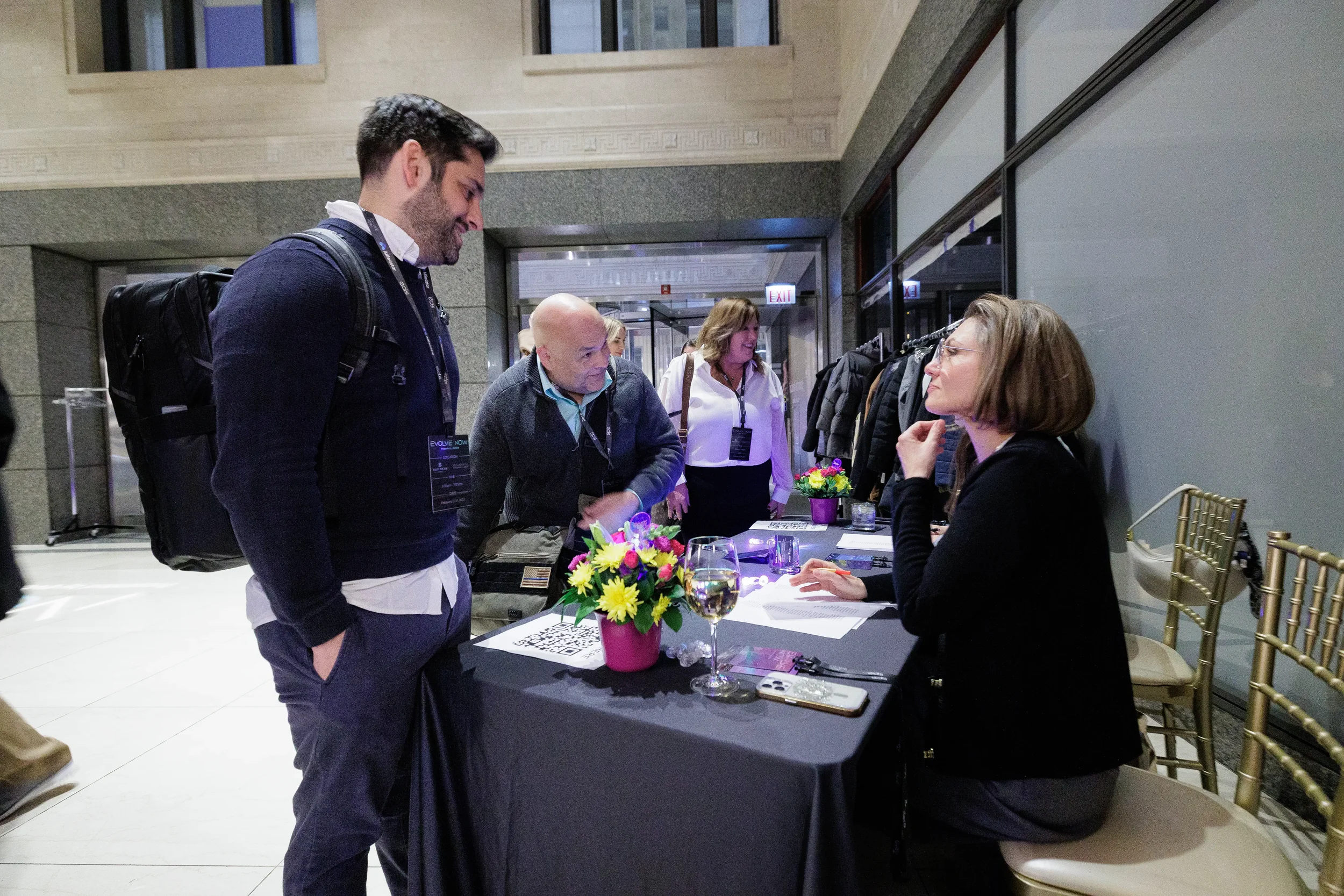 Attendees check in at registration table with floral arrangement at Orlando corporate event