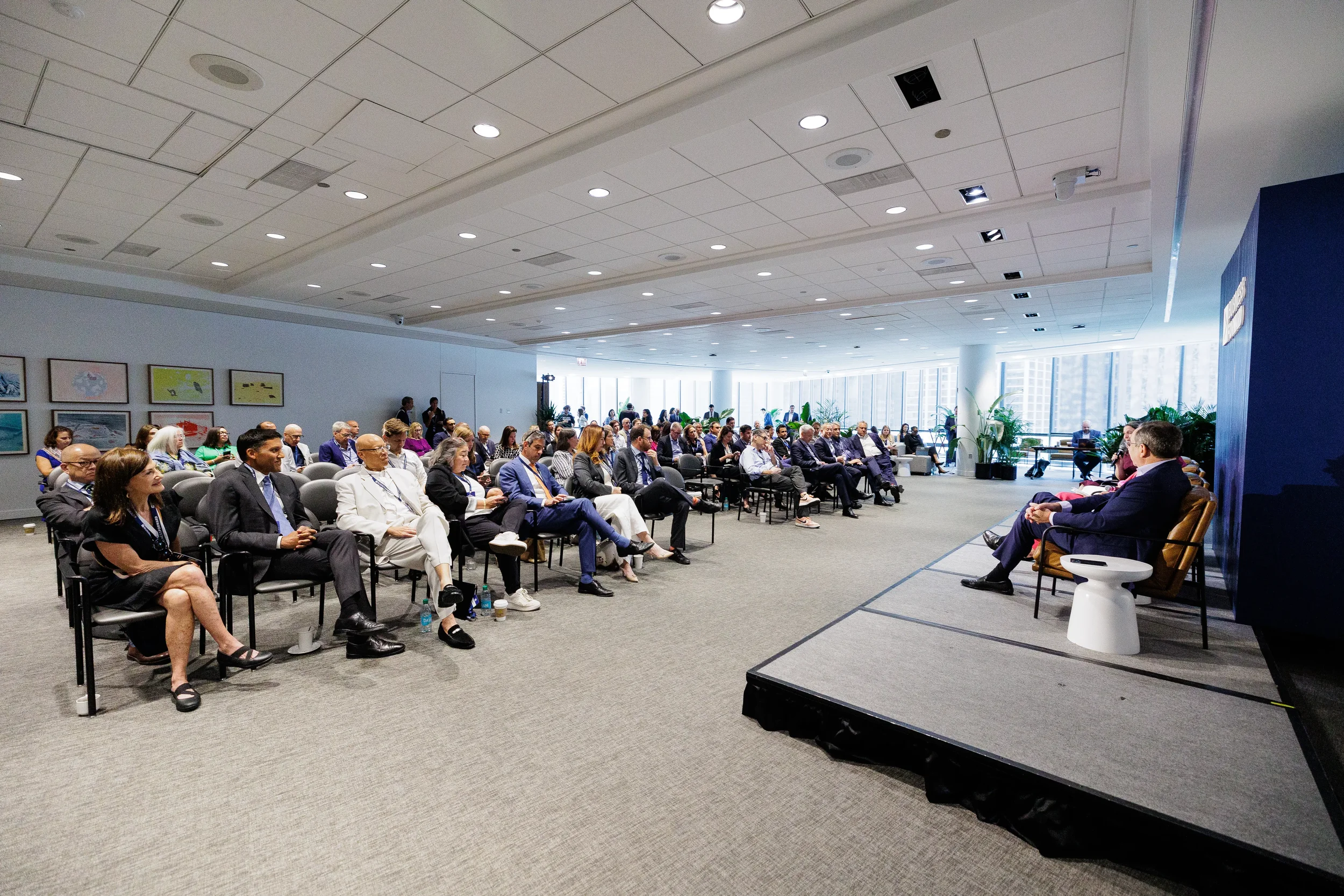 Audience watches fireside chat on stage during general session at Chicago industry event