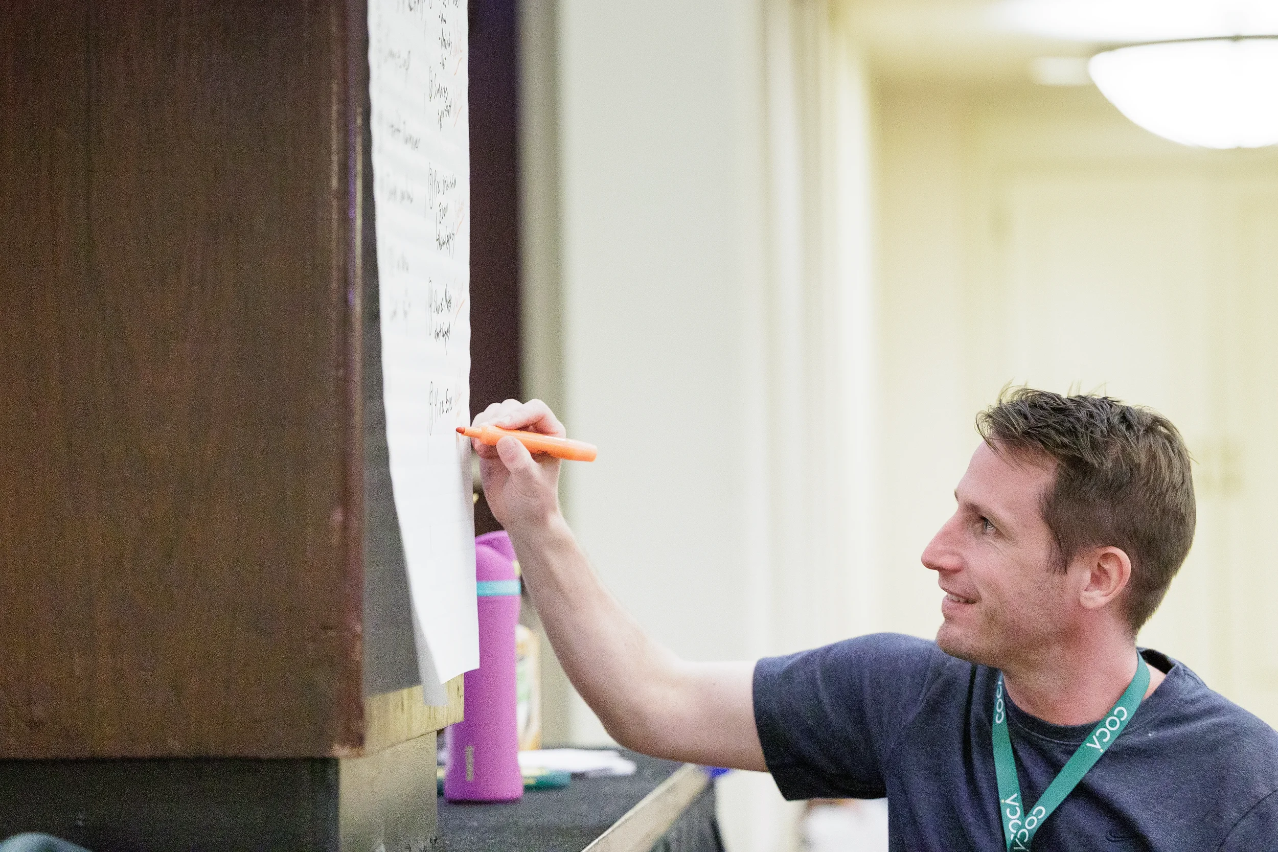 Attendee writes ideas on flipchart during workshop session at Orlando conference event