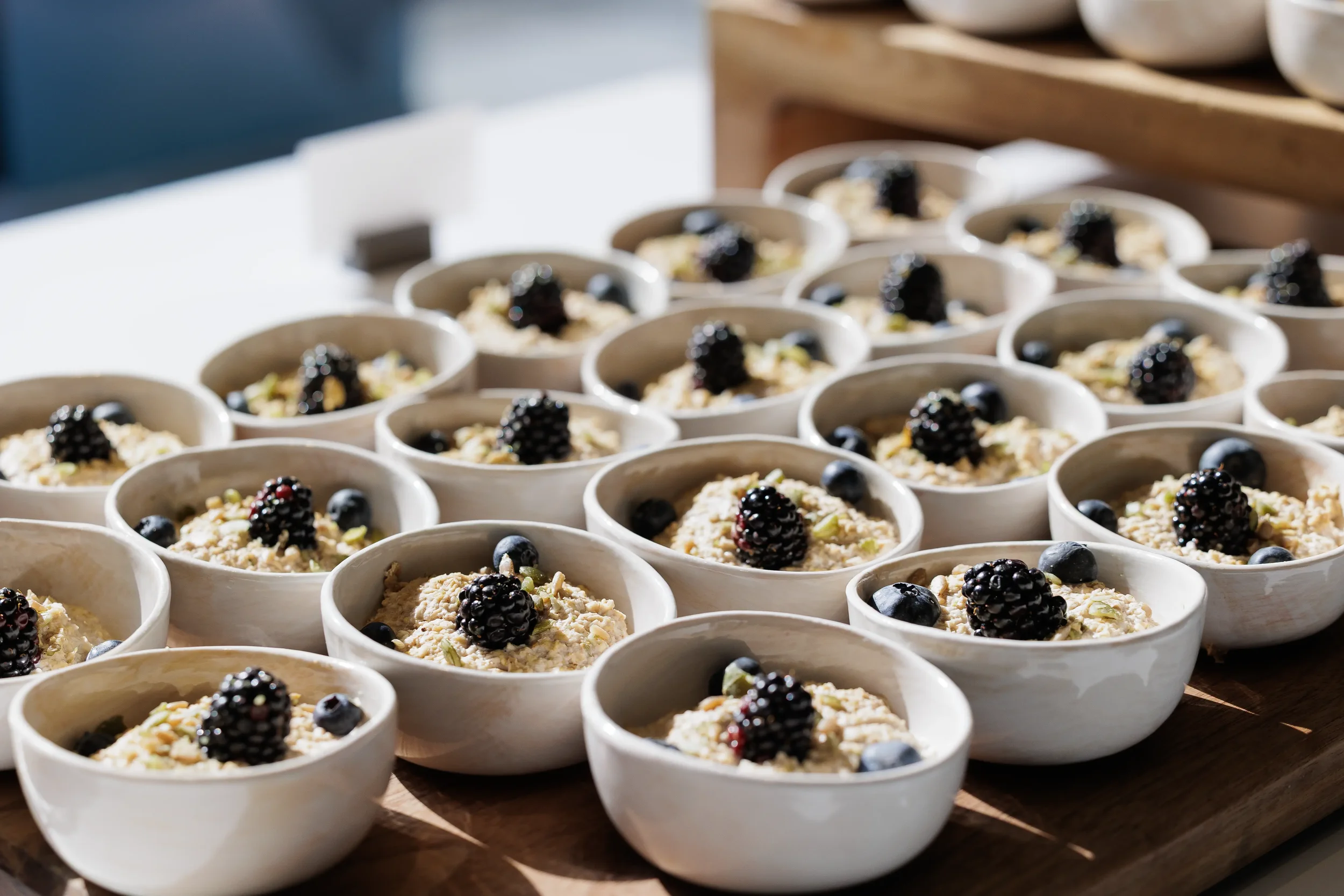 Rows of oatmeal bowls topped with blackberries and blueberries served at Chicago corporate event catering