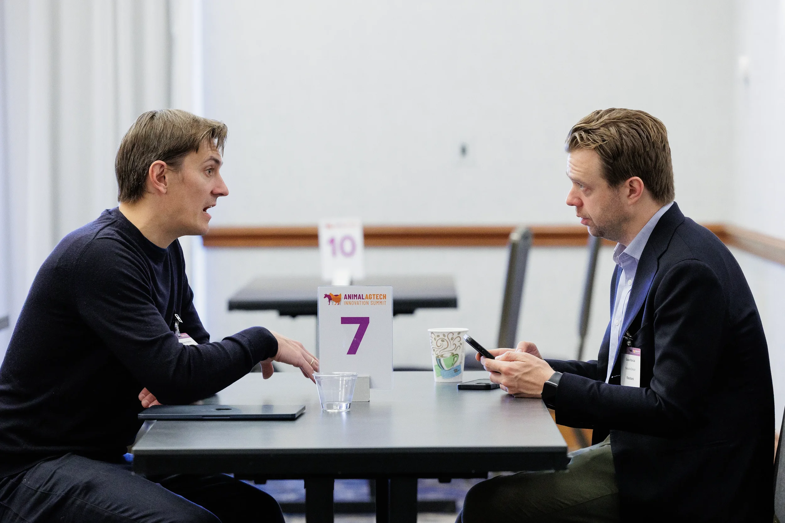 Two attendees converse at seated networking table during Orlando industry conference