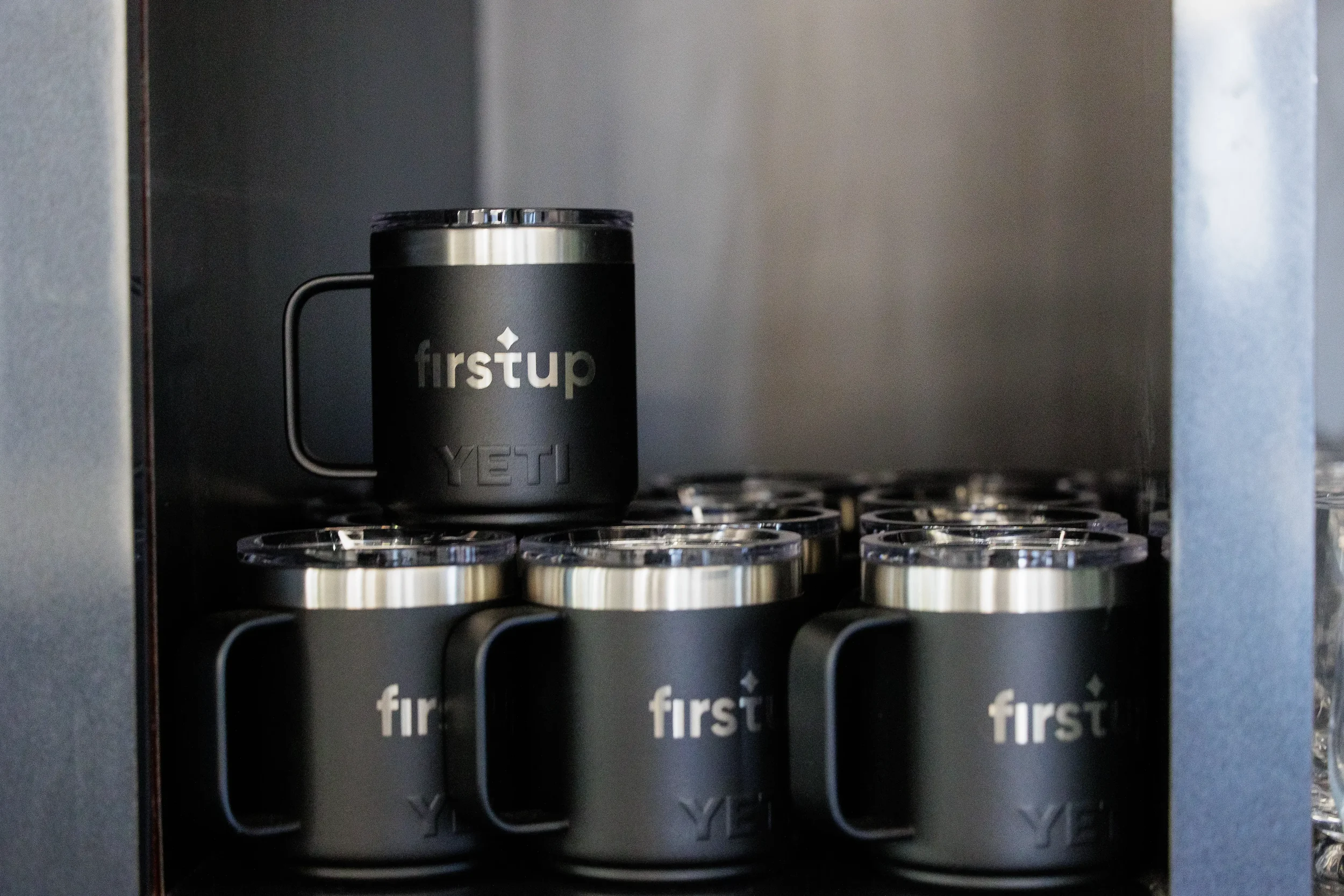 Stacked branded Yeti mugs on display as attendee swag at Chicago industry conference