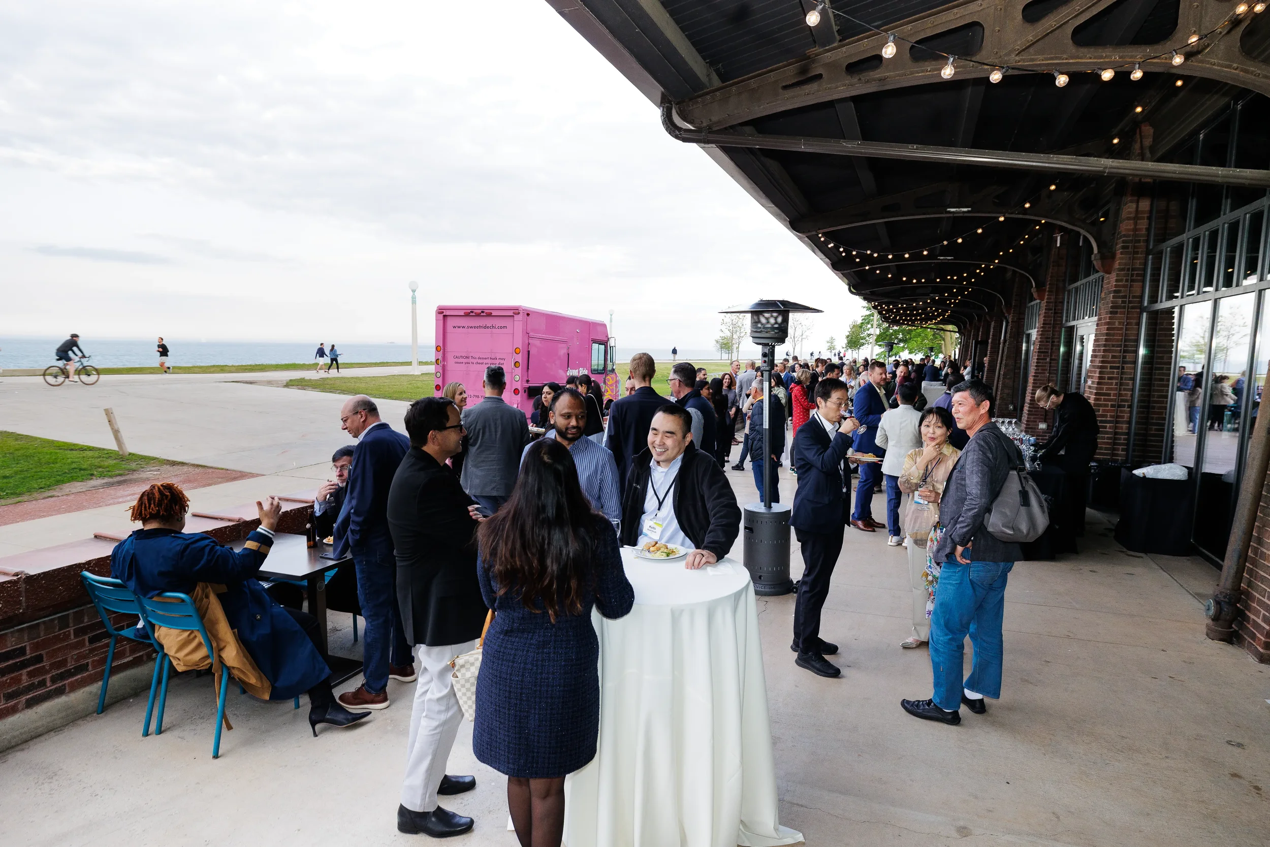Attendees mingle at outdoor lakefront reception with food truck during Chicago industry event