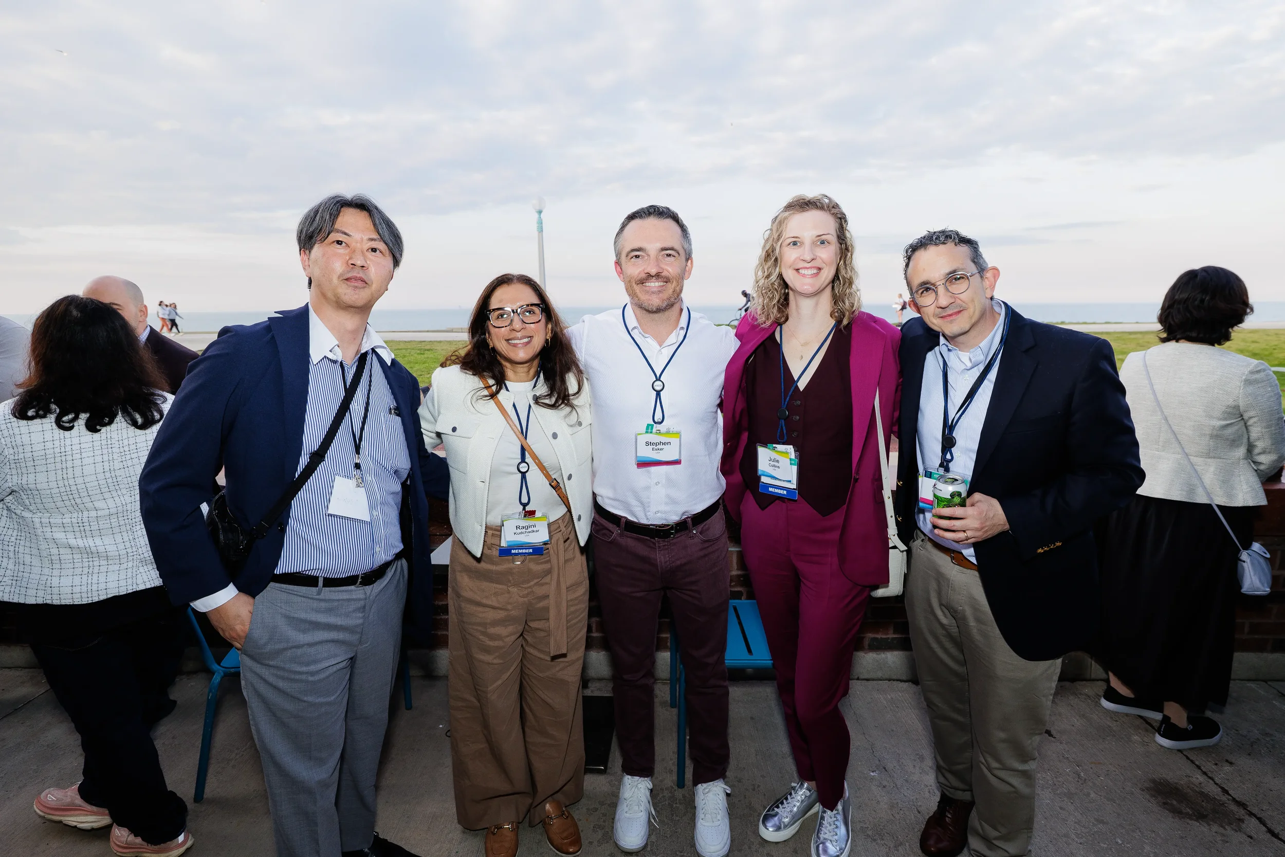 Five attendees pose together at lakefront reception during Chicago networking event