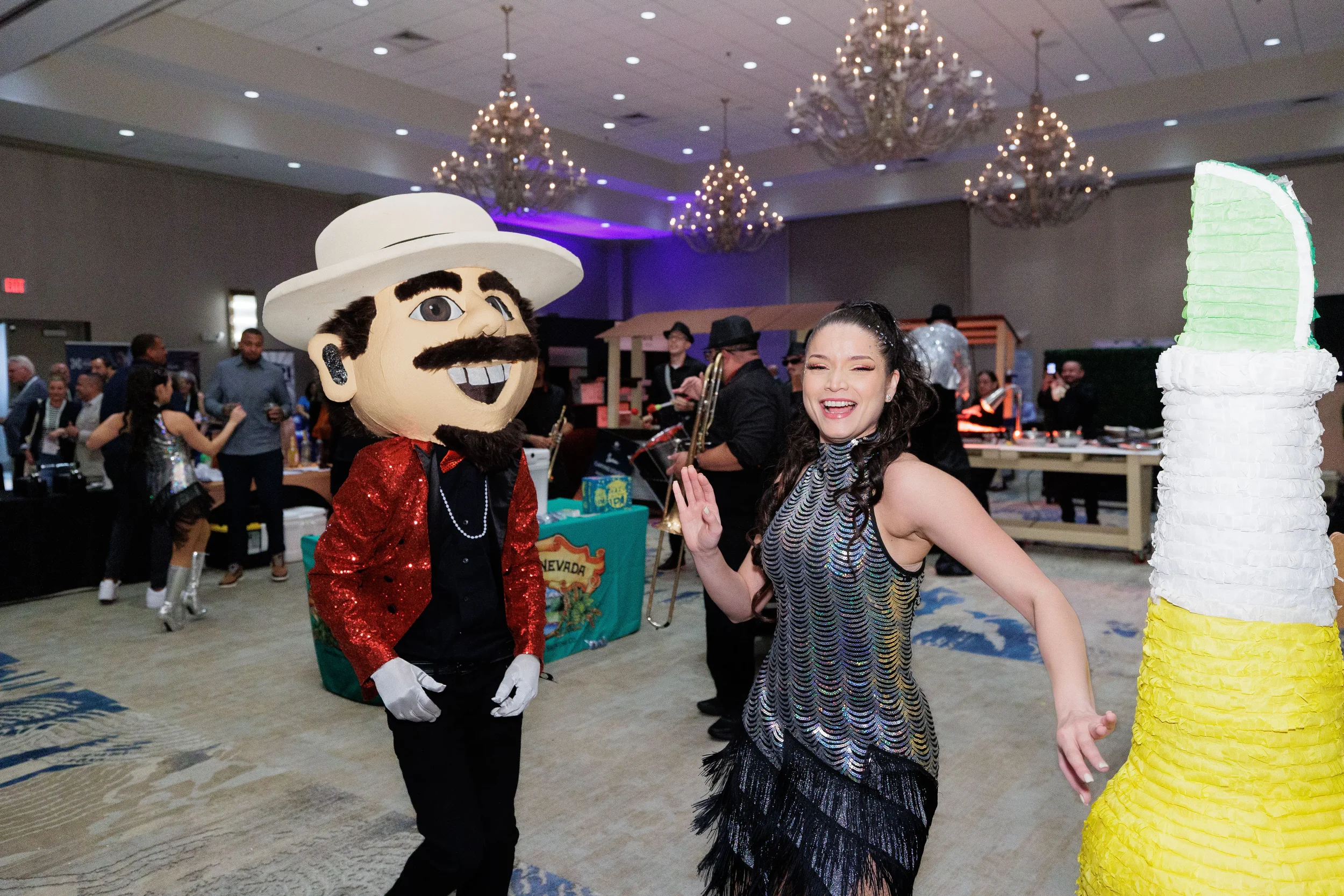 Costumed mascot and fringe dancer perform together near giant piñata at Chicago corporate event expo