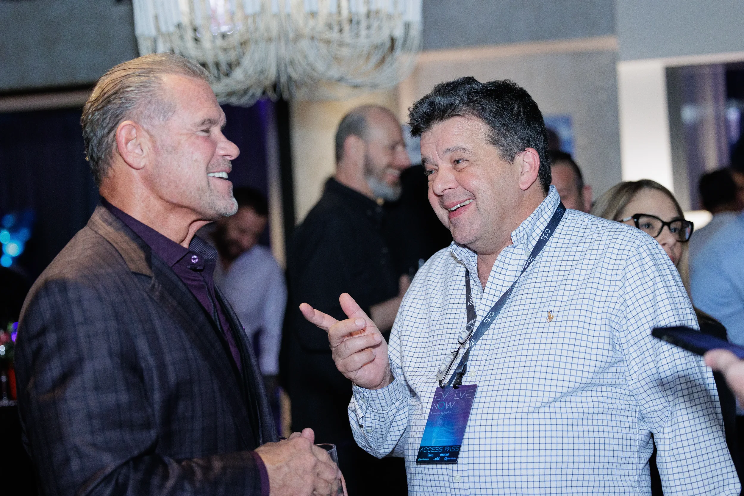 Two attendees laugh and gesture in conversation during networking reception at Chicago corporate event