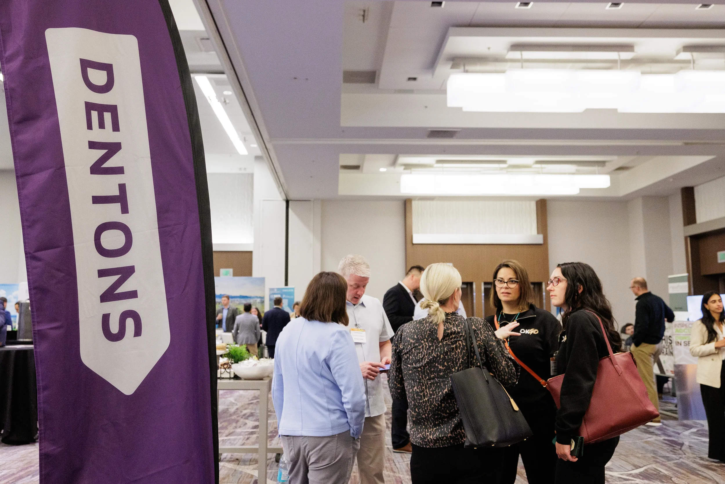 Attendees network near sponsor banner during reception at Chicago corporate event