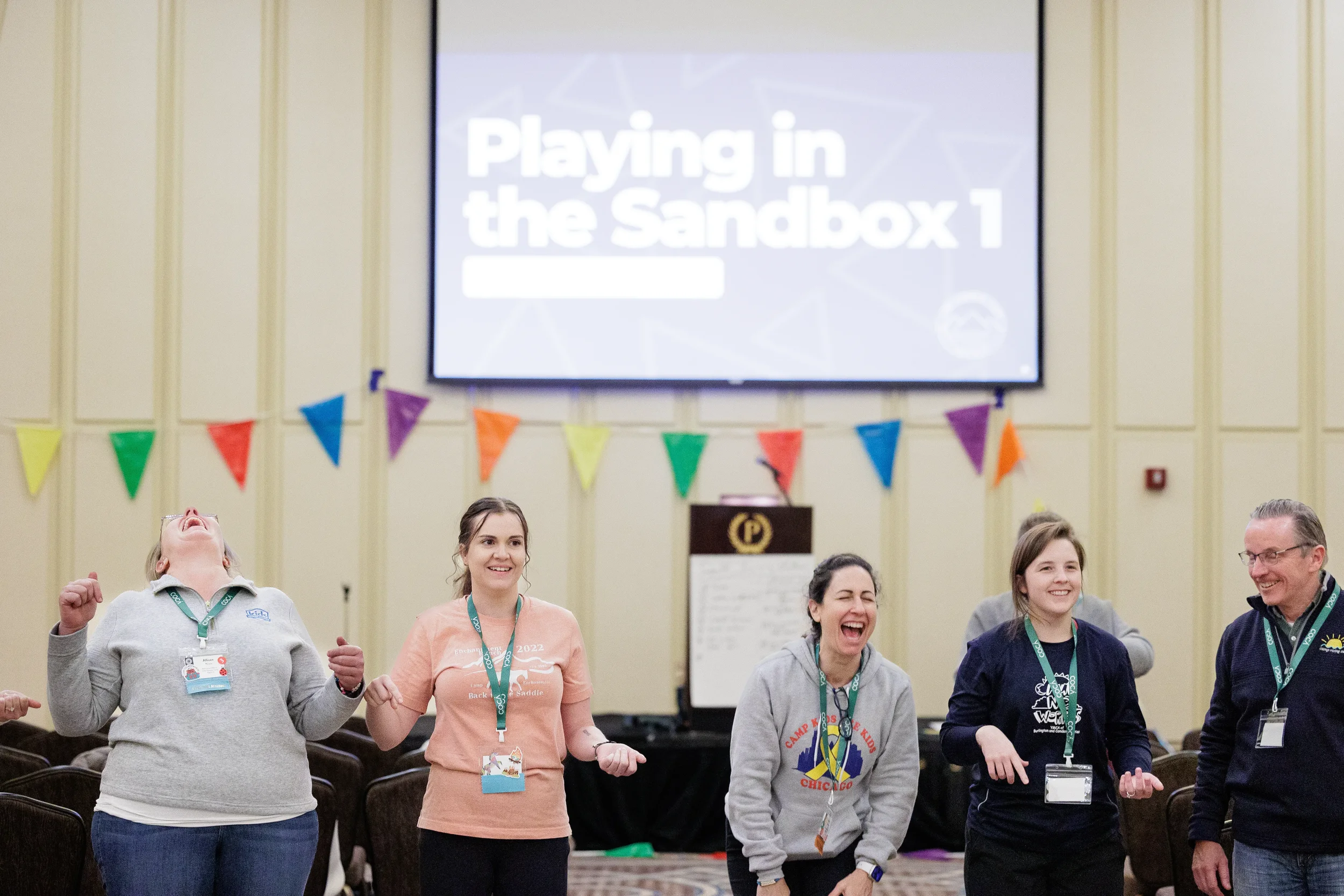 Group of attendees laugh together during energetic interactive session in ballroom at Orlando nonprofit conference