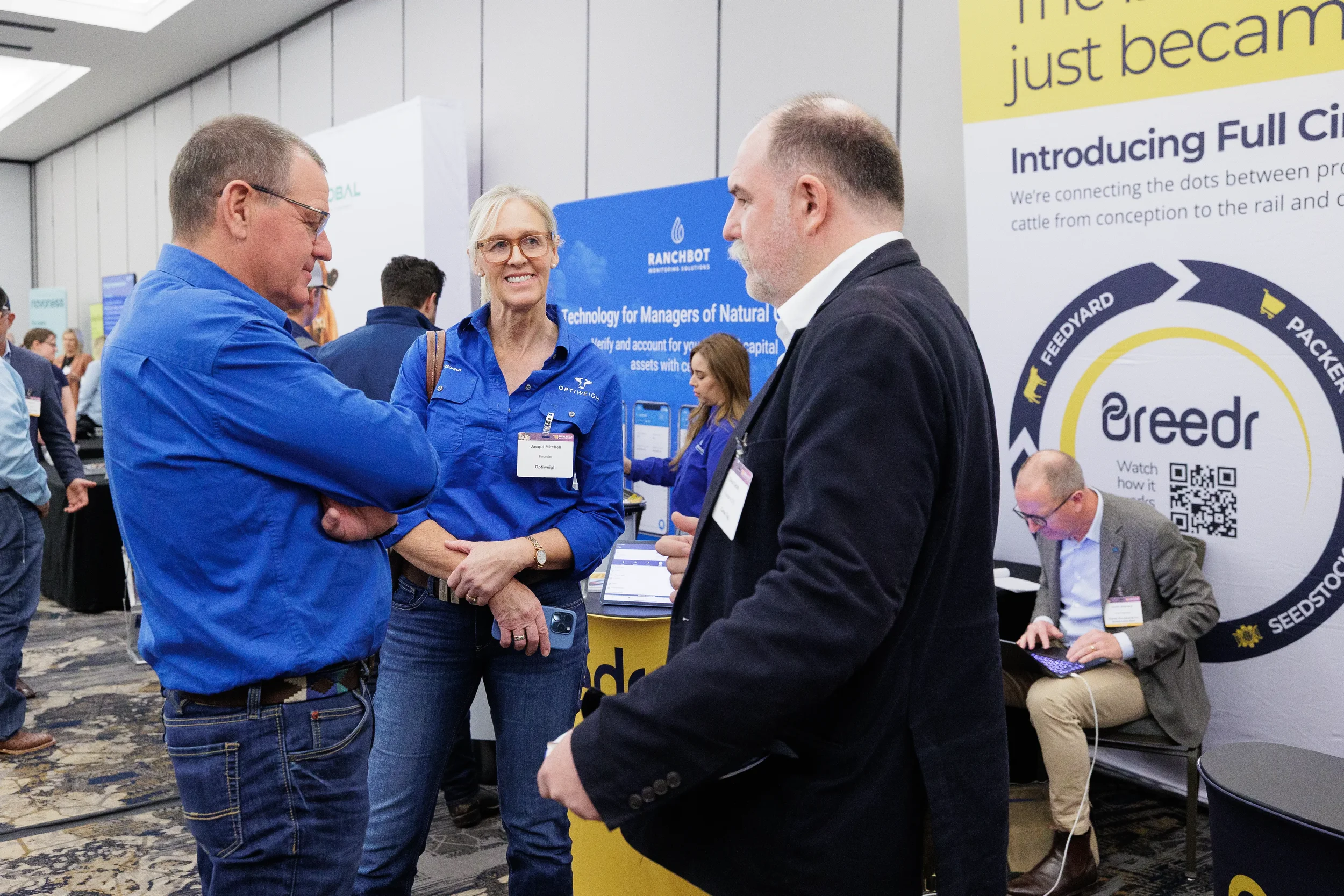 Attendees converse at technology expo booth during Orlando industry trade show