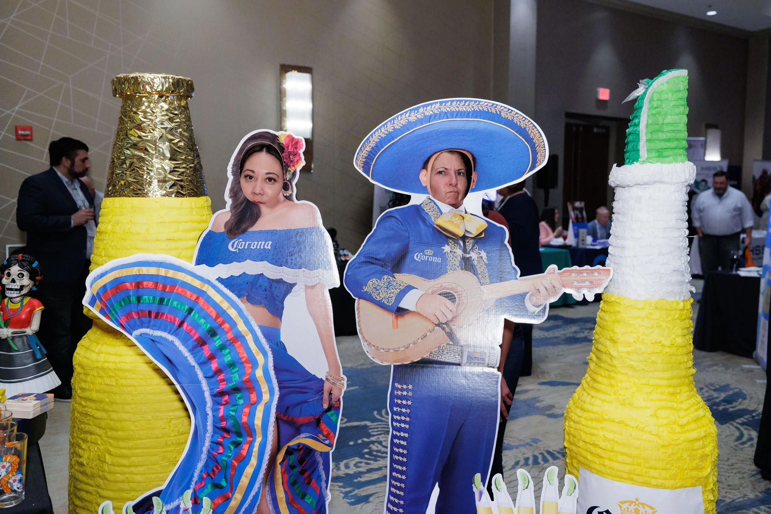 Festive themed cutout displays and oversized piñata bottle decorations on Chicago corporate conference expo floor