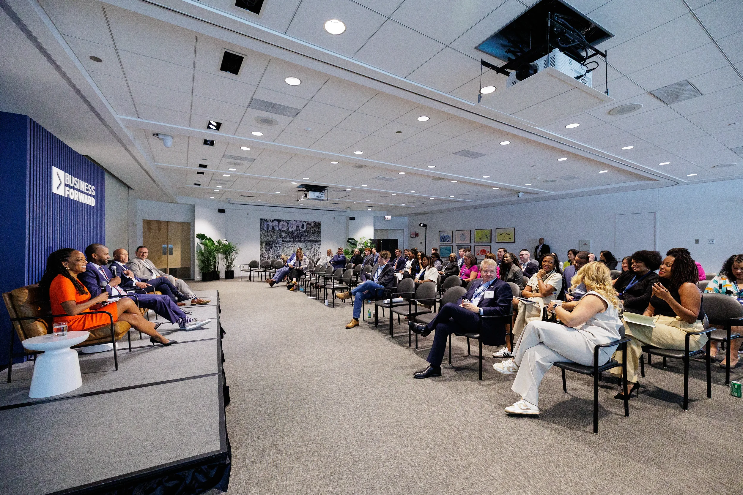 Audience watches panel discussion from seated rows during session at Chicago corporate event